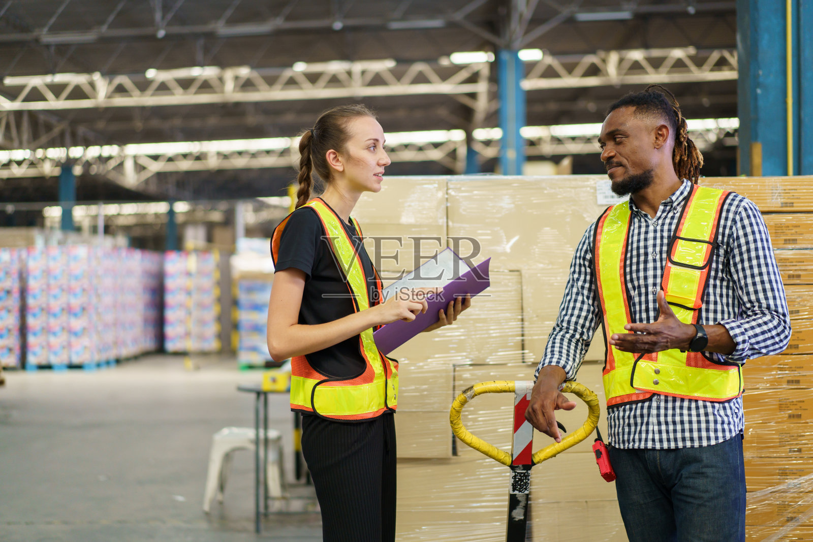 仓库工作人员在仓库检查一个纸箱。照片摄影图片