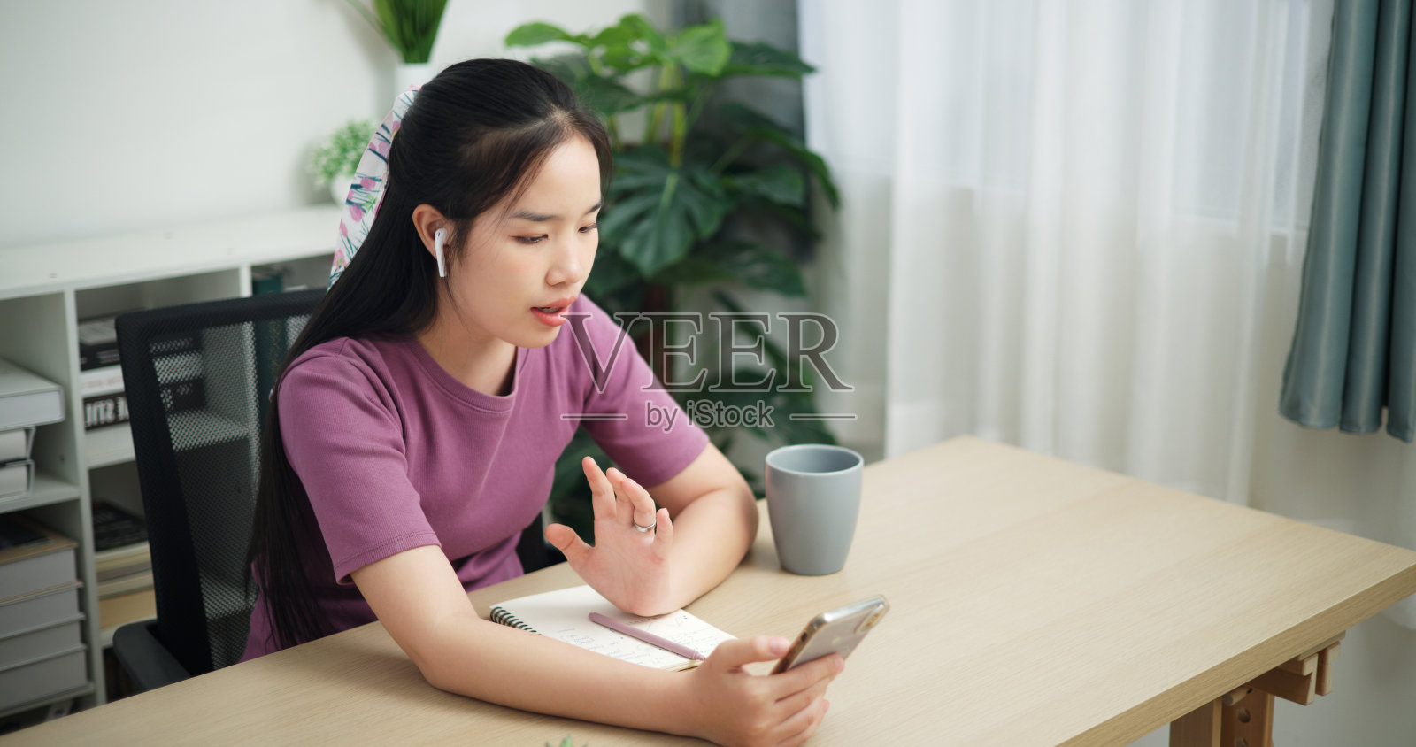 女商人在家里用手机进行视频通话。照片摄影图片