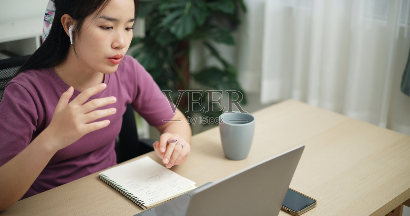 特写，一位商务女性正在家里用笔记本电脑开会。照片摄影图片