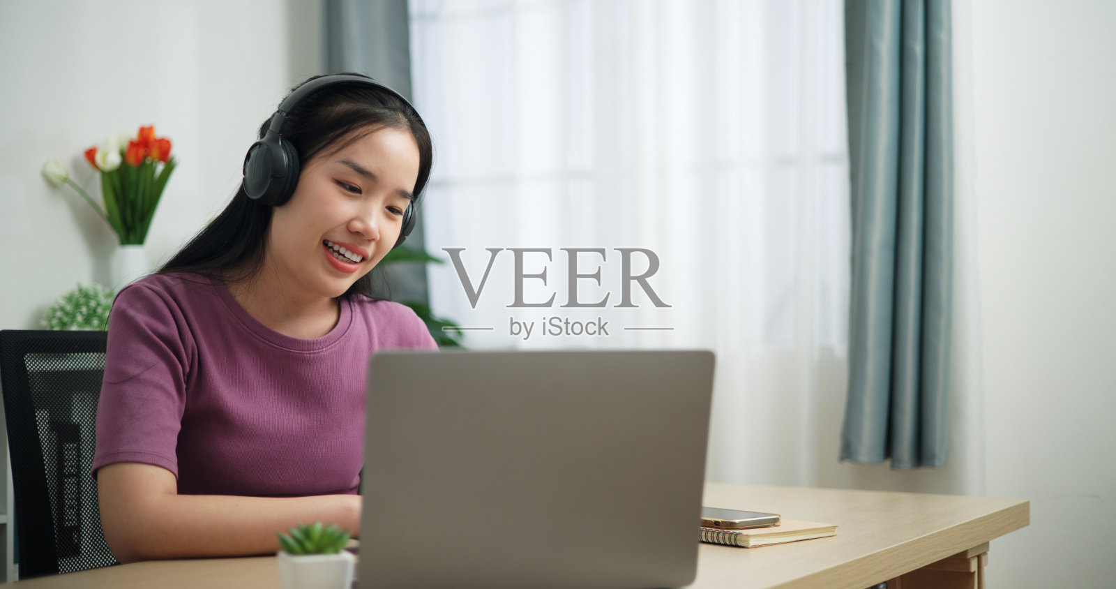 微笑的商务女性正在家里用笔记本电脑开会视频通话。照片摄影图片