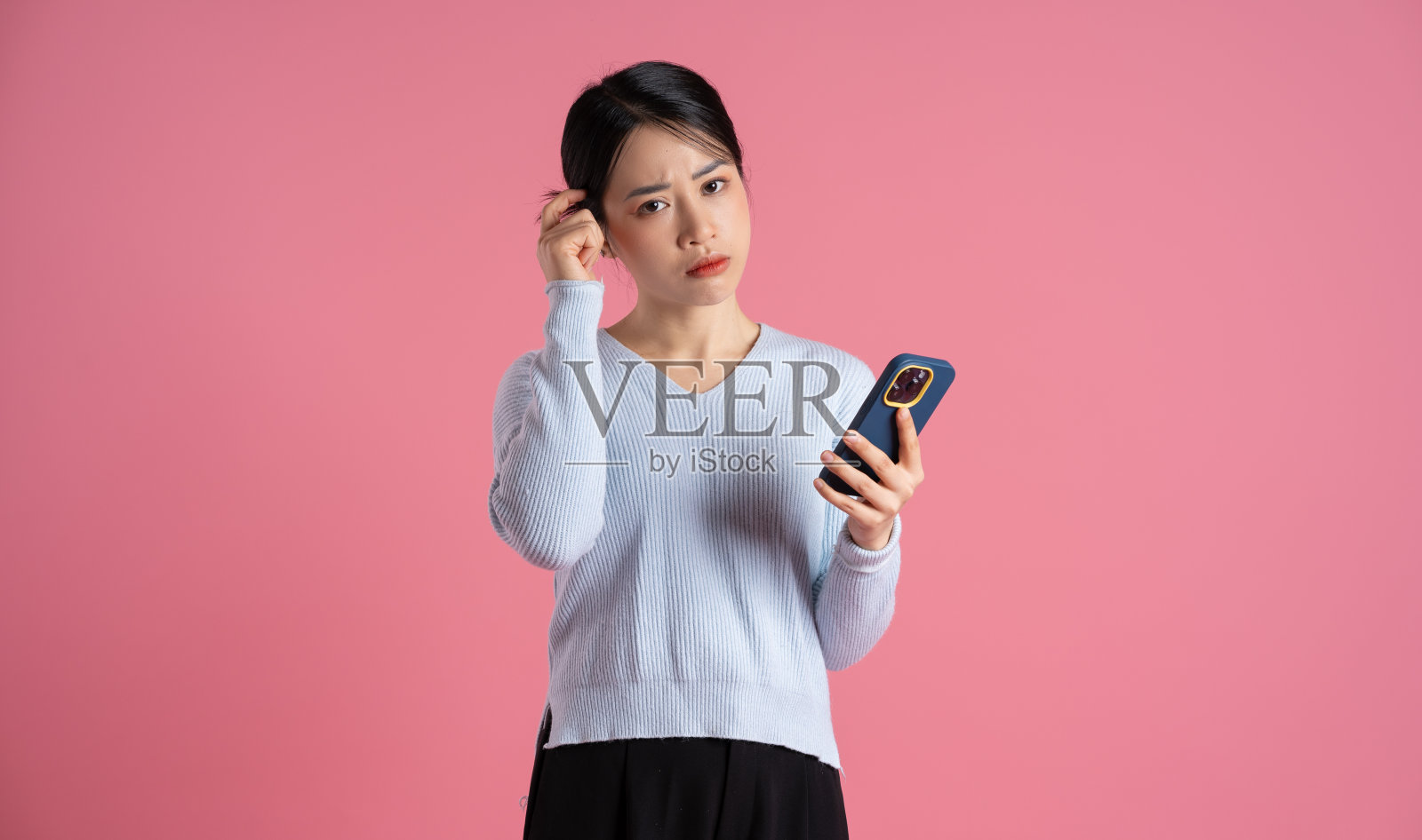 美丽的亚洲女人在粉红色背景上摆姿势的肖像照片摄影图片