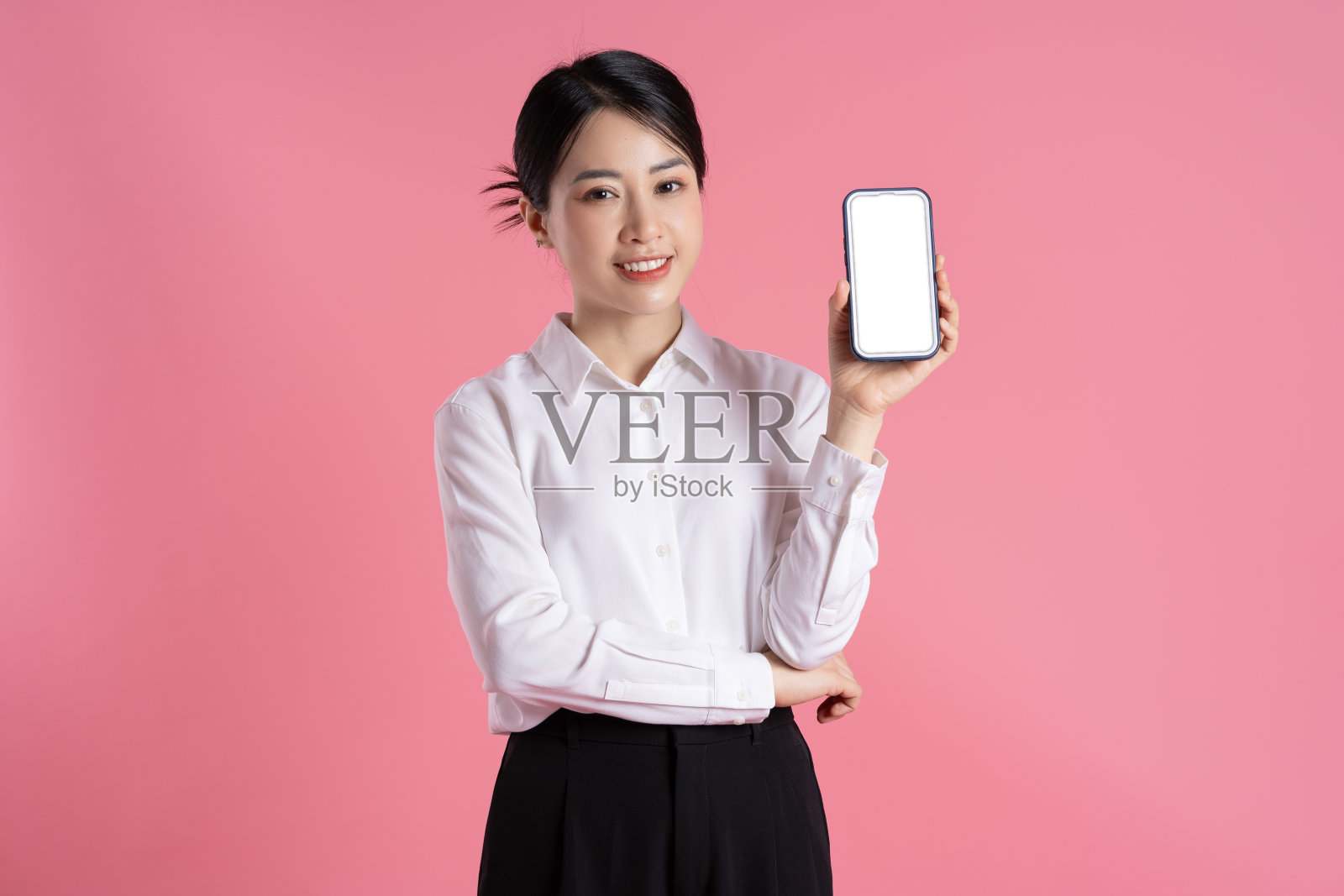 美丽的亚洲女商人在粉红色背景上摆姿势的肖像照片摄影图片