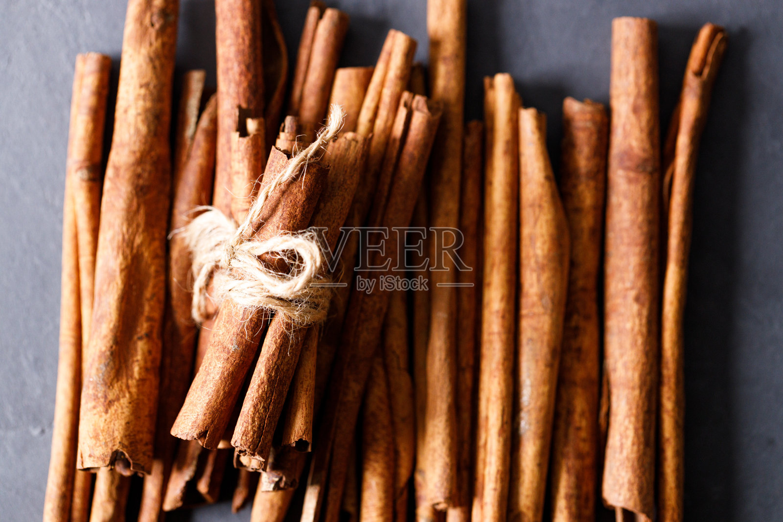 肉桂棒干树皮香料黑石桌的背景。有选择性的重点。照片摄影图片