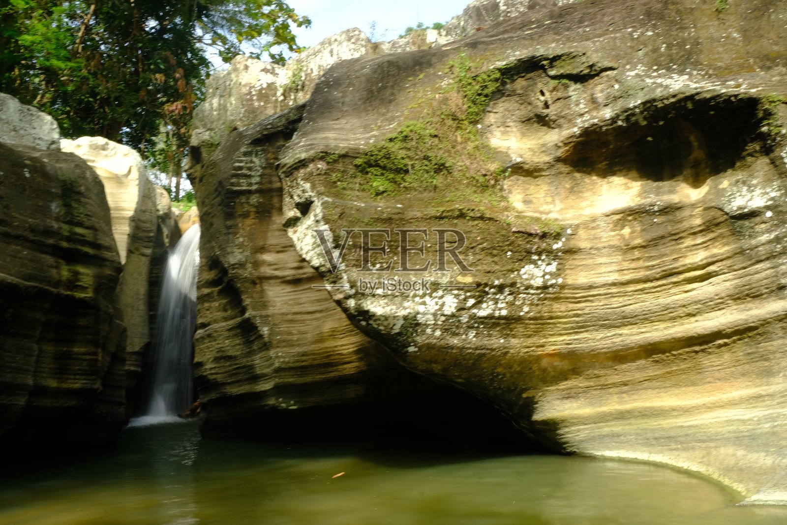 瀑布在沉积岩壁之间。自然背景。照片摄影图片