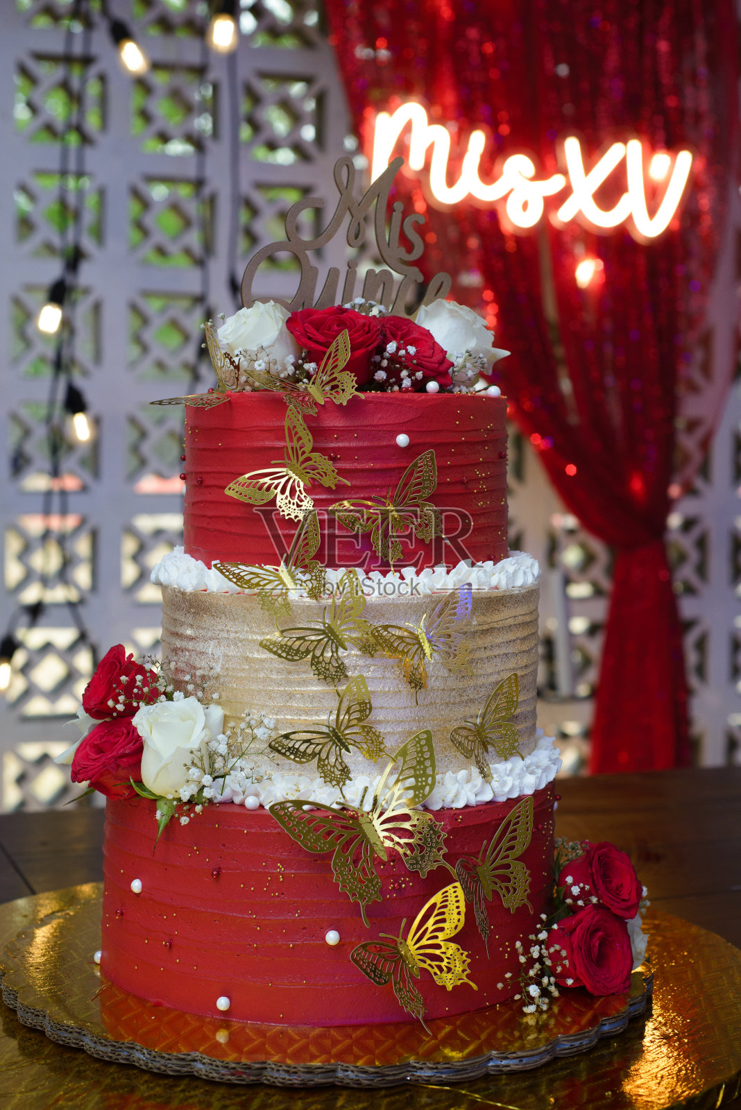 送给十五岁女孩的漂亮生日蛋糕。红白相间的蛋糕，装饰着玫瑰和蝴蝶。照片摄影图片