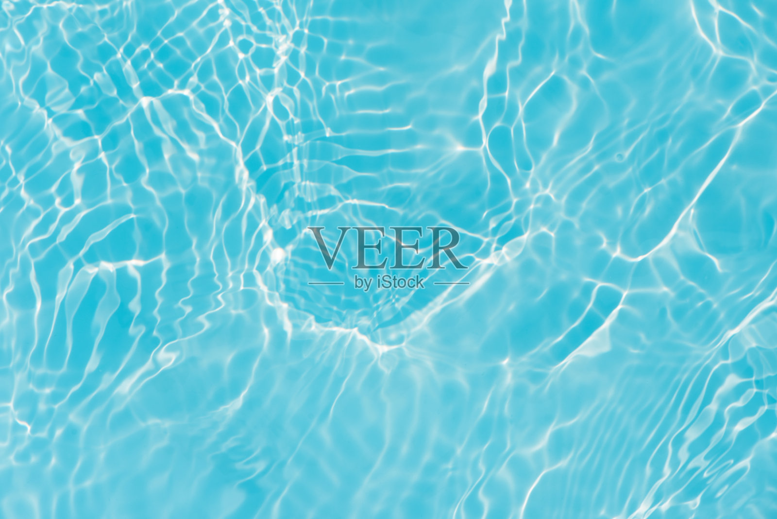 蓝蓝的水面上泛起涟漪。散焦模糊透明蓝色透明平静水面纹理与飞溅和气泡。水波与闪亮的图案纹理背景。照片摄影图片