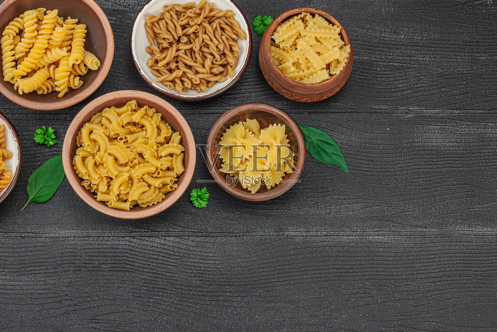 意大利面。木制背景上的各种生面食和面条。传统的意大利照片摄影图片