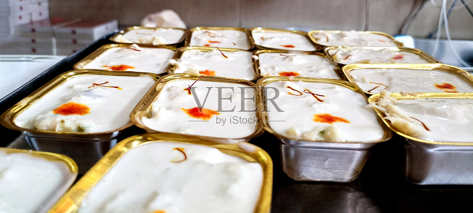 由纯牛奶制成的甜拉布迪或拉布里，配以沙沙。装在碗里，在糖果店忧郁的背景下享用照片摄影图片