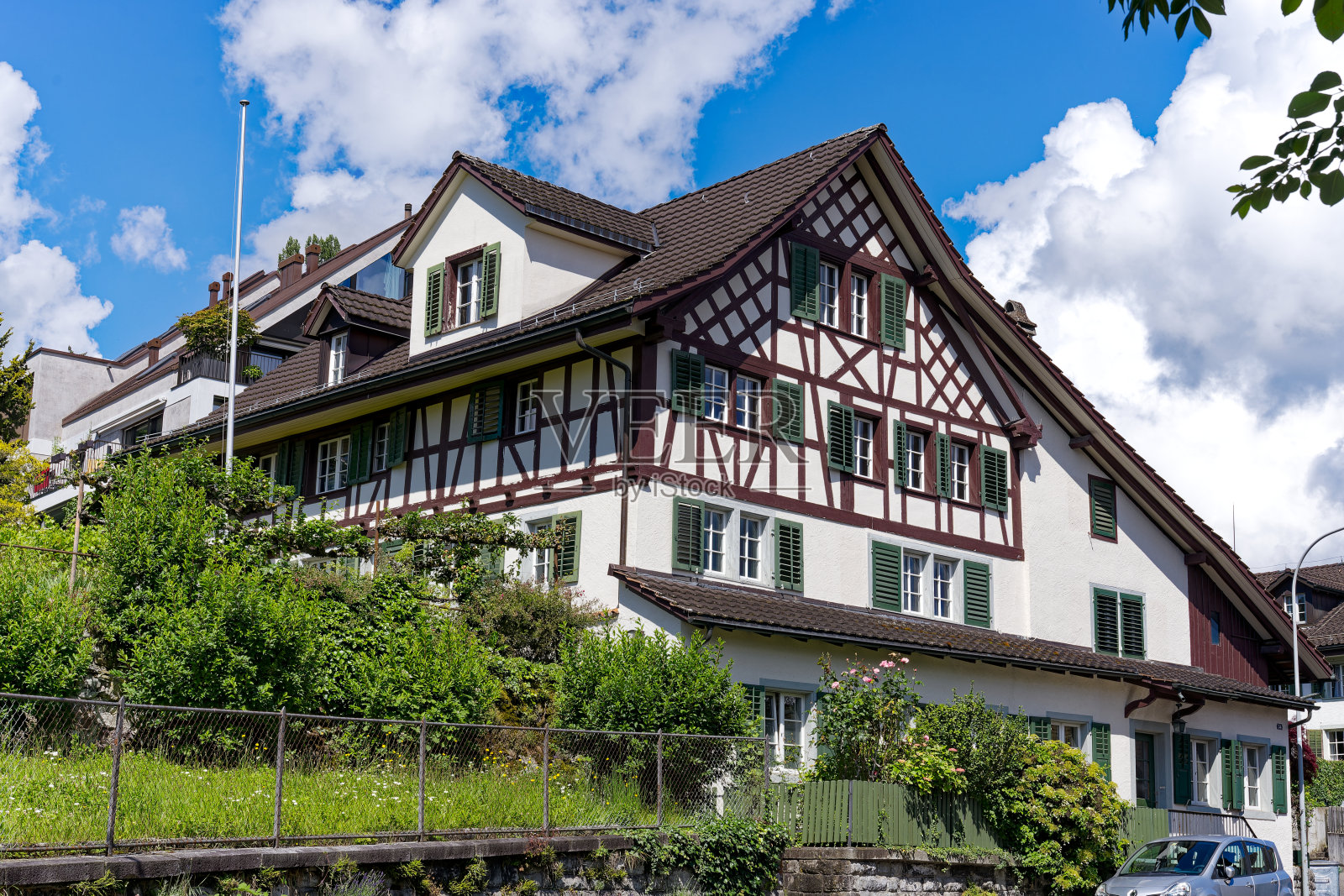 在明亮的阳光下，瑞士村庄的传统老房子田园诗般的风景。照片摄影图片