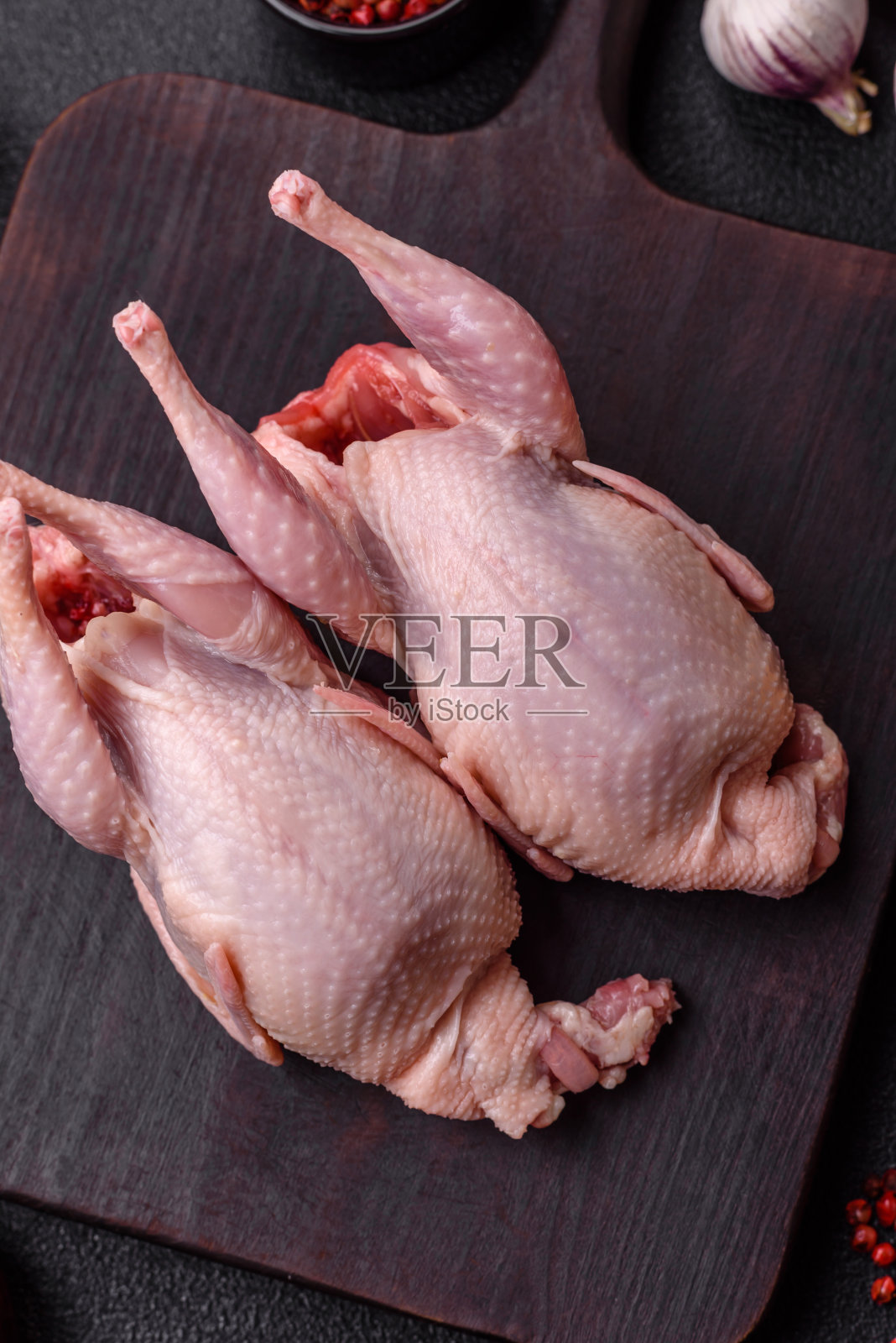 整只生鹌鹑，加盐，香料和香草，黑色混凝土背景照片摄影图片