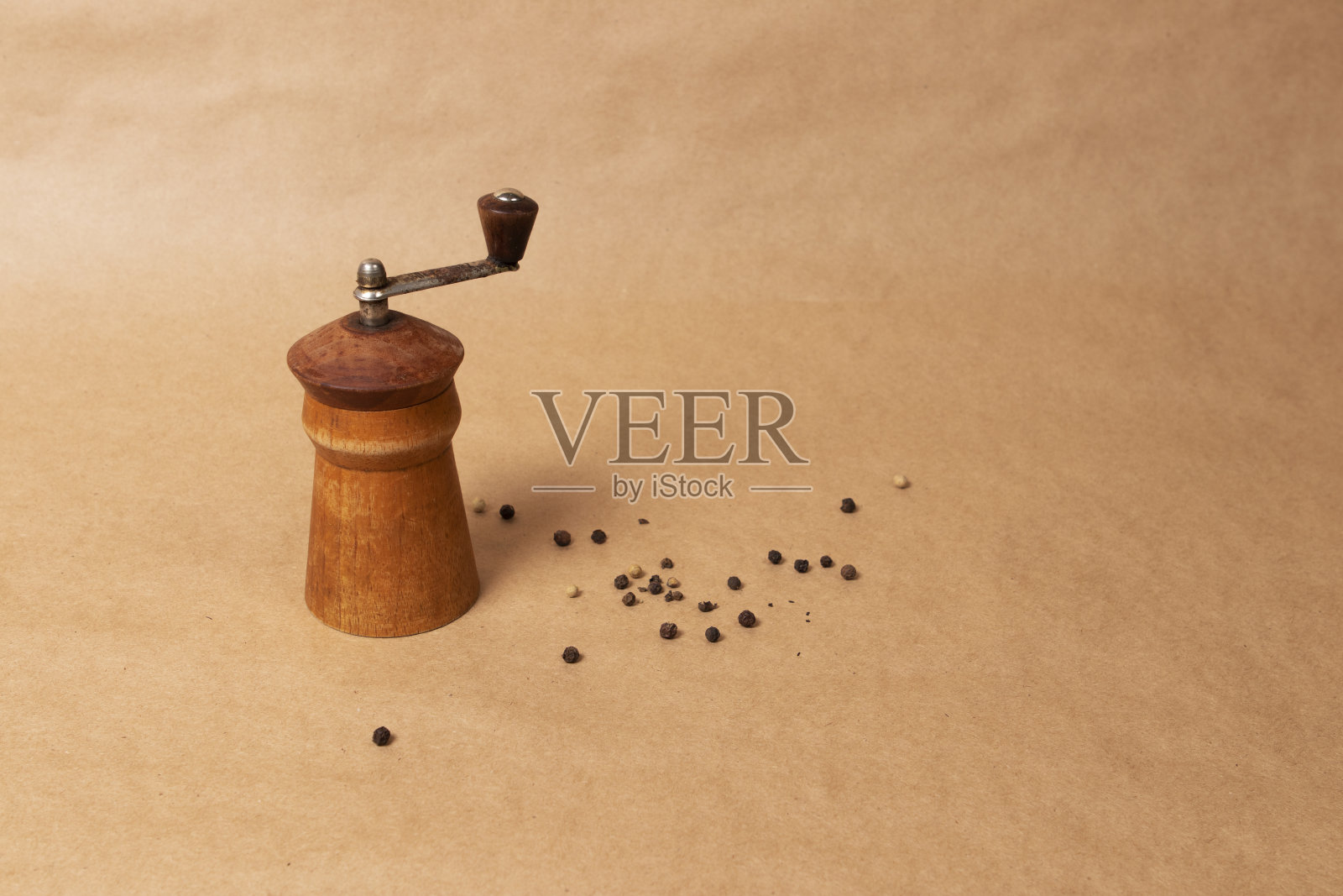 棕色背景上的旧木制黑胡椒磨照片摄影图片