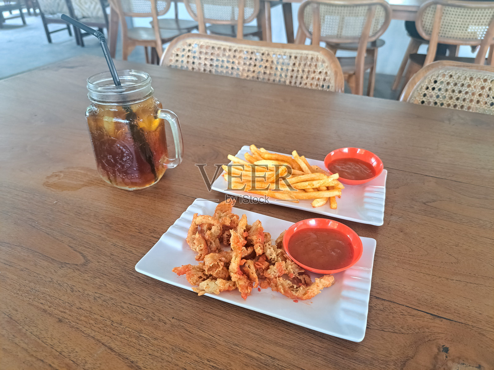 美味的蚵仔菇Jamur Balado和薯条Balado配上酱汁。冰鲜茶或加糖杯。食物和饮料菜单。照片摄影图片