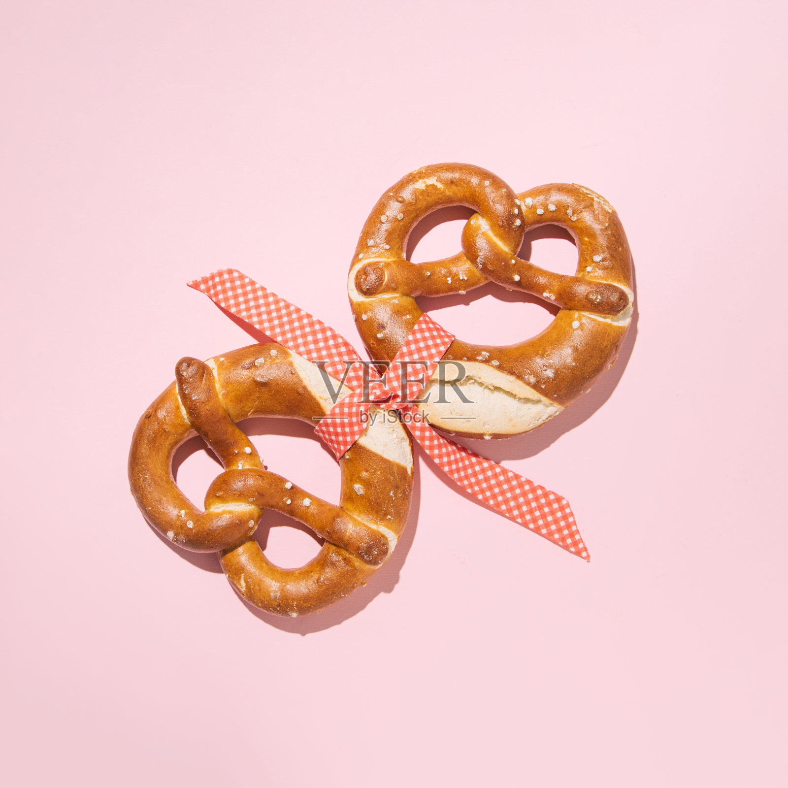 两个椒盐卷饼用装饰丝带系在一起照片摄影图片