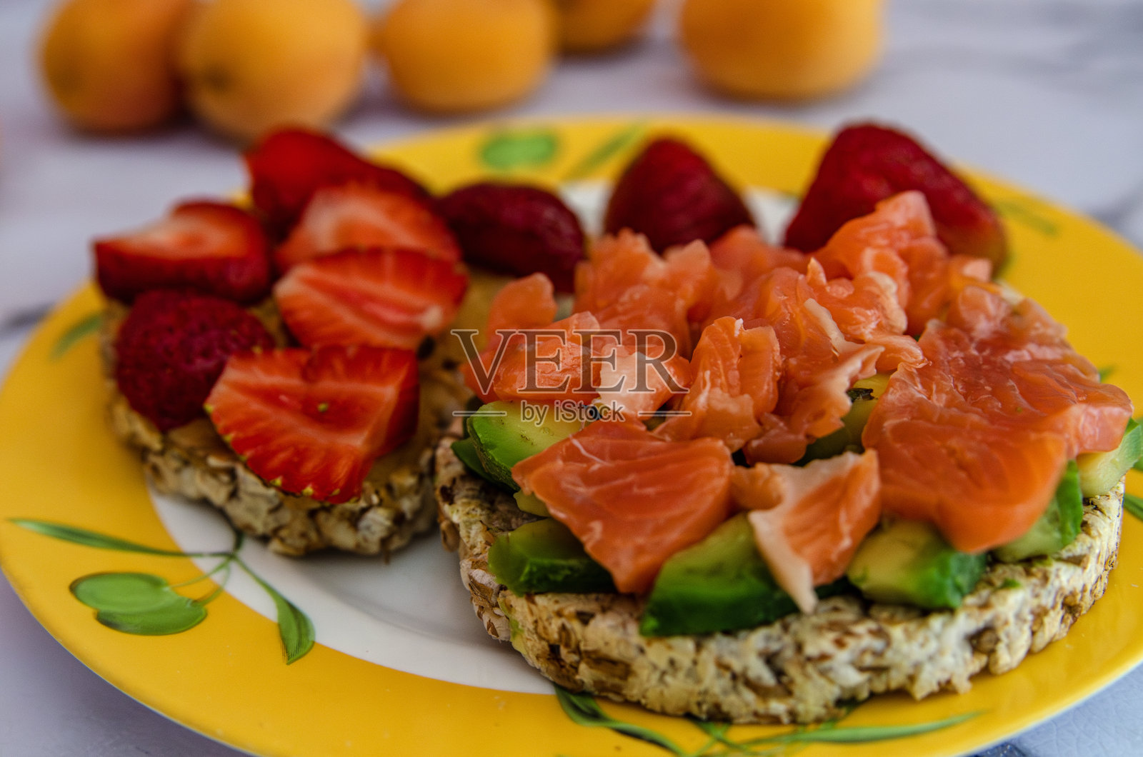 美味的三文鱼鳄梨三明治盘，草莓水果的背景，特写照片摄影图片
