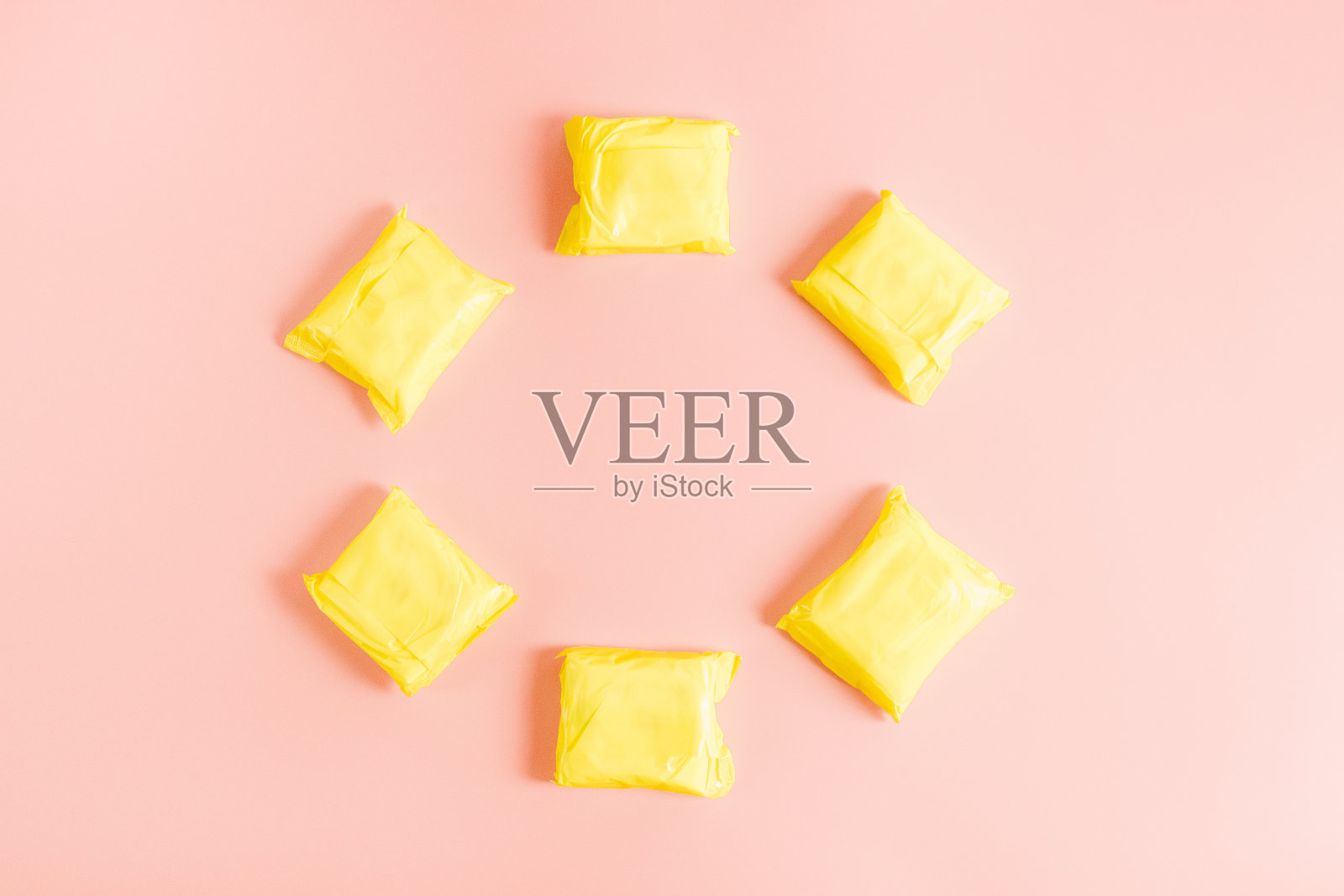 粉红色背景上的六块黄色女式护垫。照片摄影图片