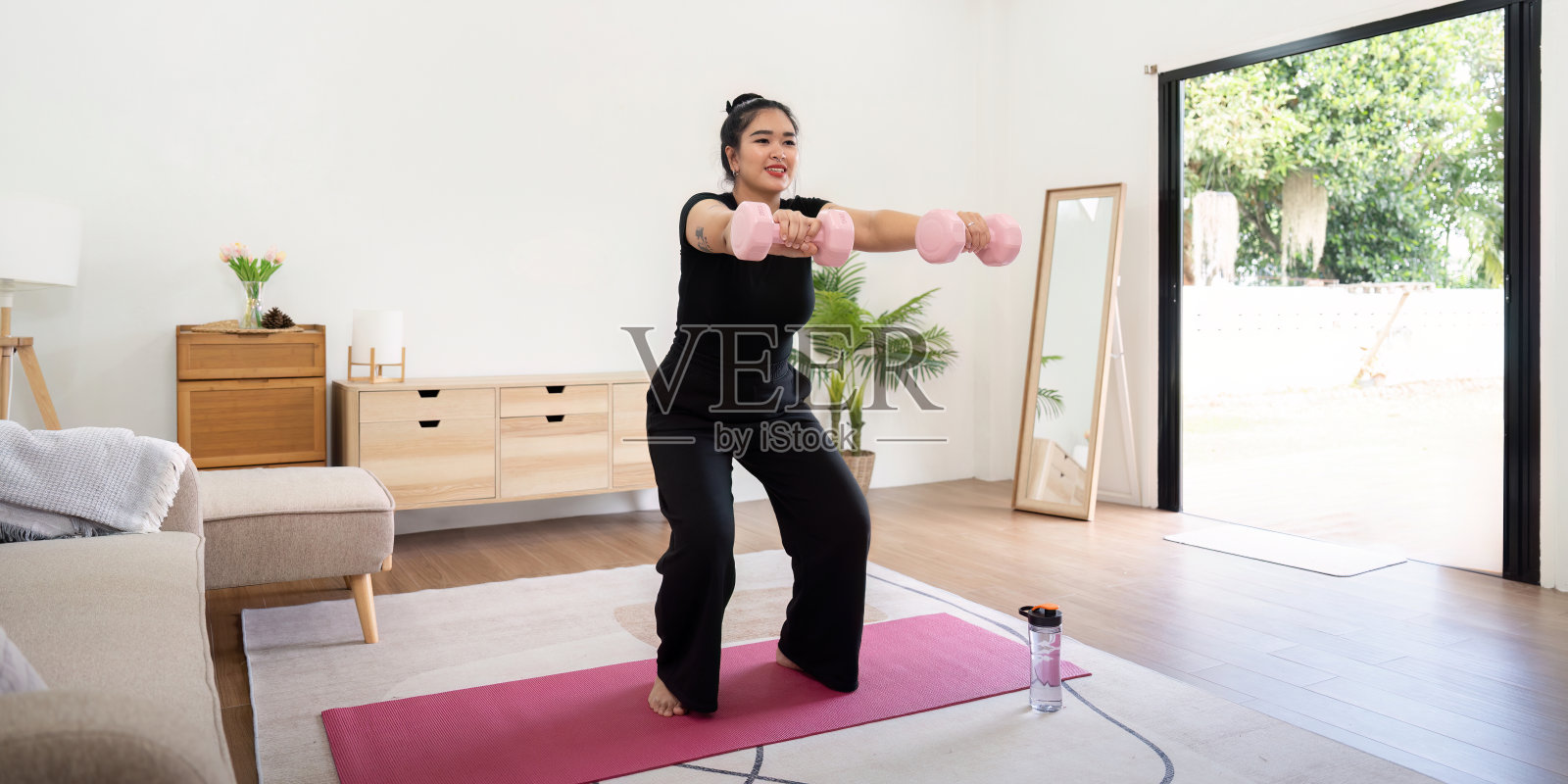 超重妇女参与家庭锻炼，以实现减肥目标和改善健康照片摄影图片