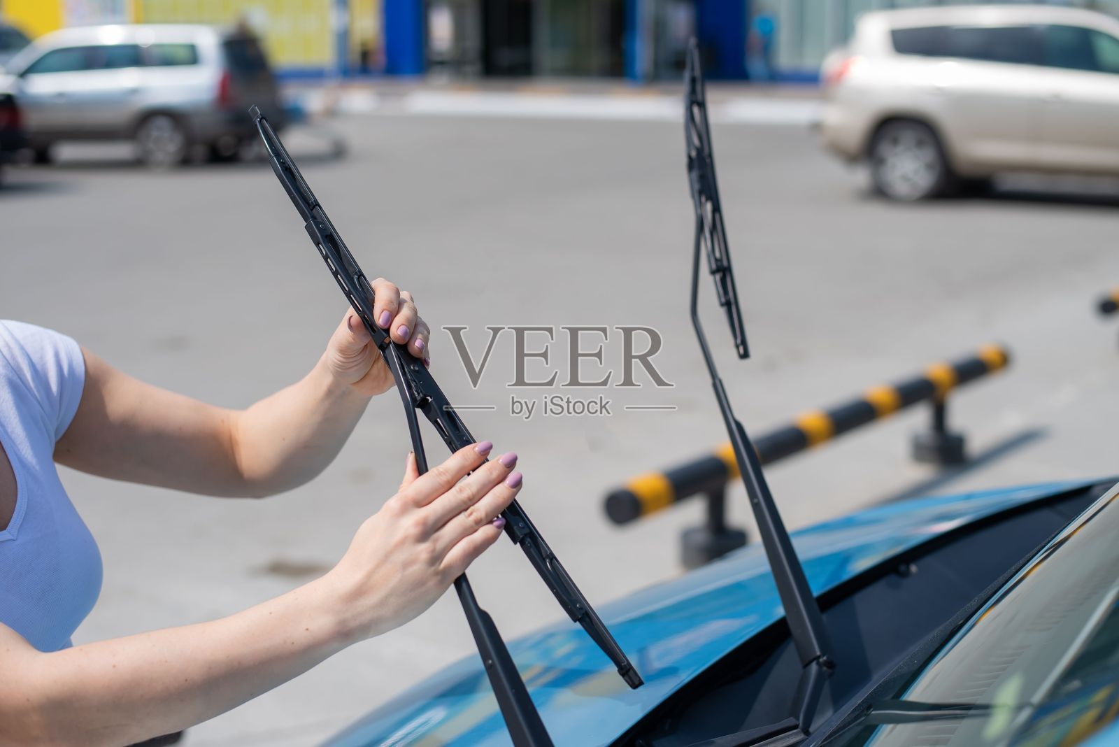 无脸女人换汽车挡风玻璃刮水器。照片摄影图片