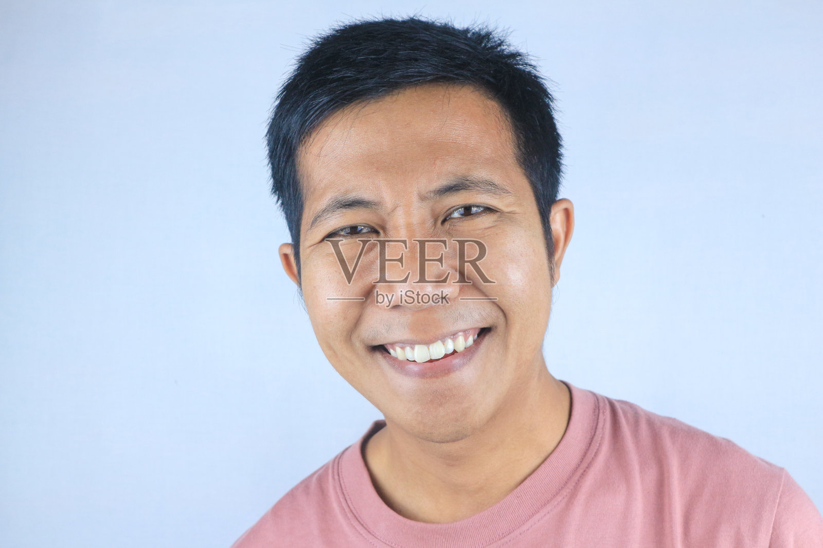 微笑的面部表情年轻的亚洲男子高兴地看着相机，孤立在白色的背景照片摄影图片