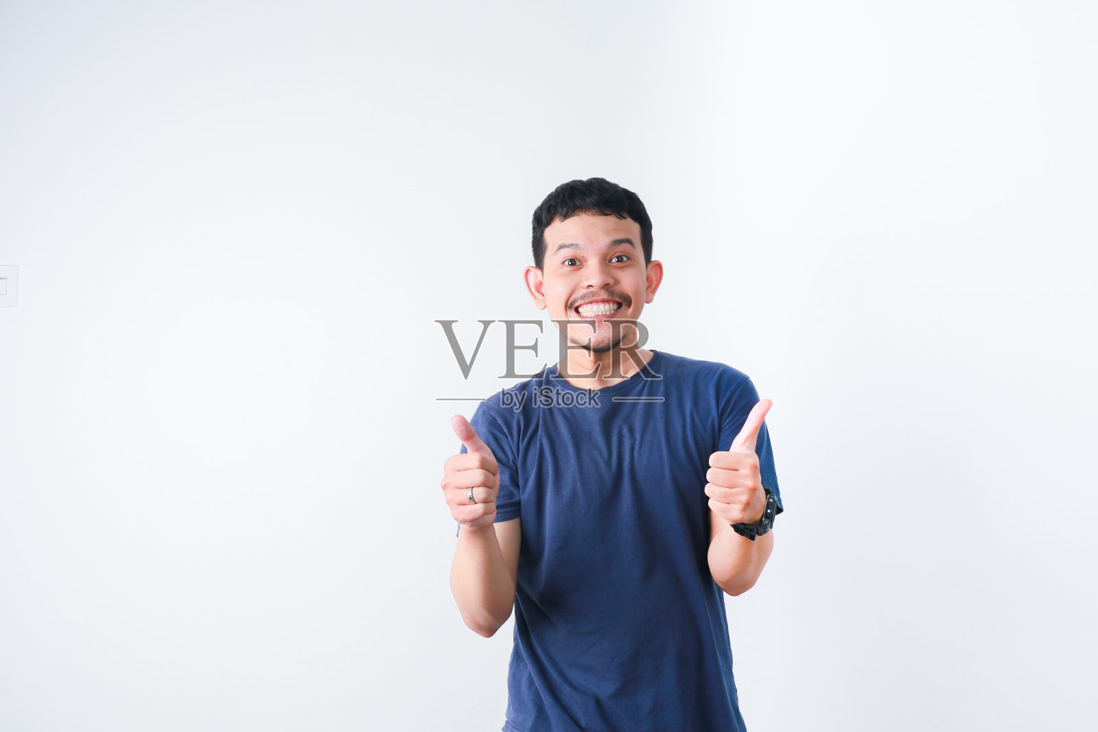 非常快乐的年轻亚洲人维克多。紧握的双手，举起，孤立在灰色的背景中。照片摄影图片