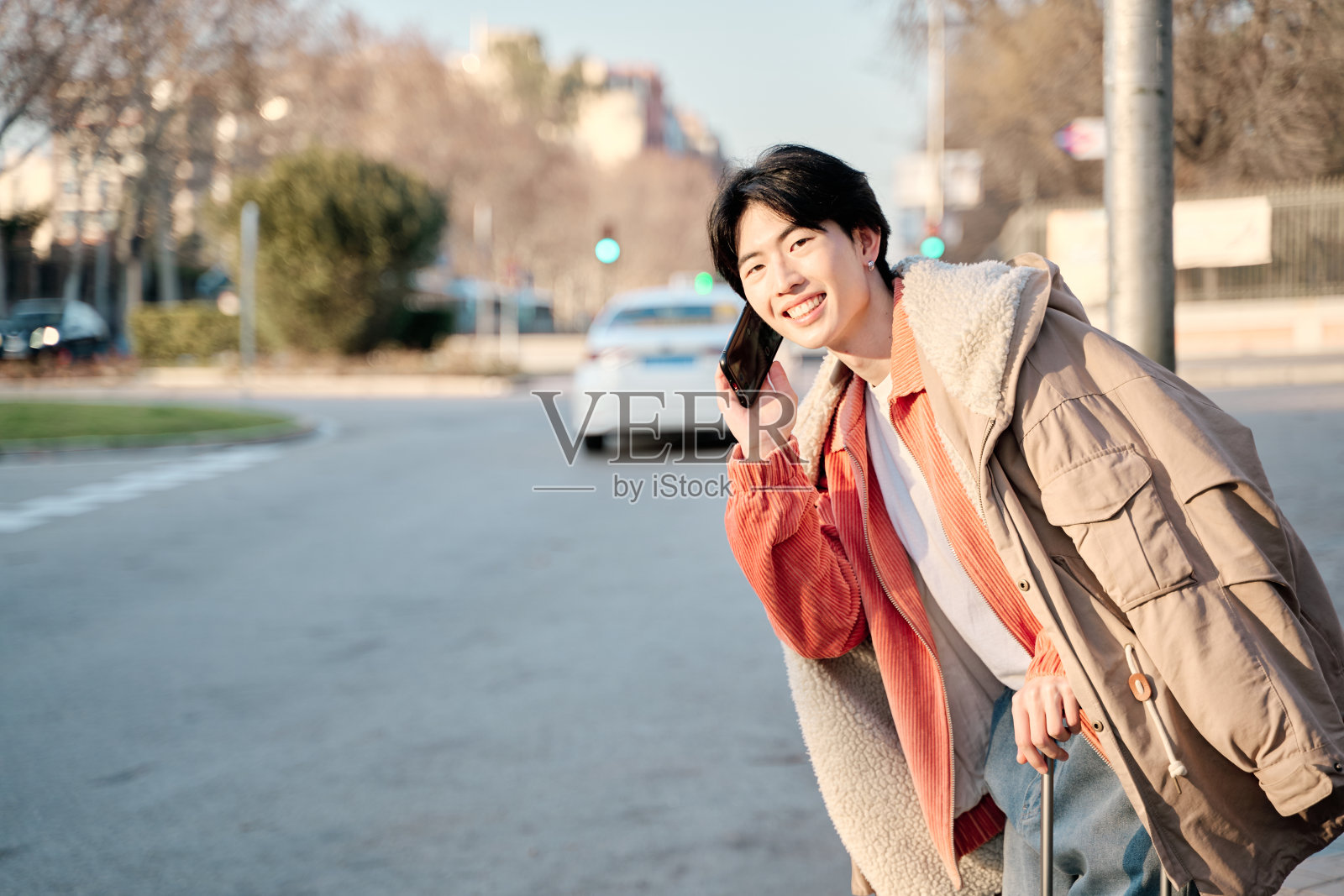 时髦的年轻亚洲男子时髦的年轻亚洲男子讲电话等出租车去旅行照片摄影图片