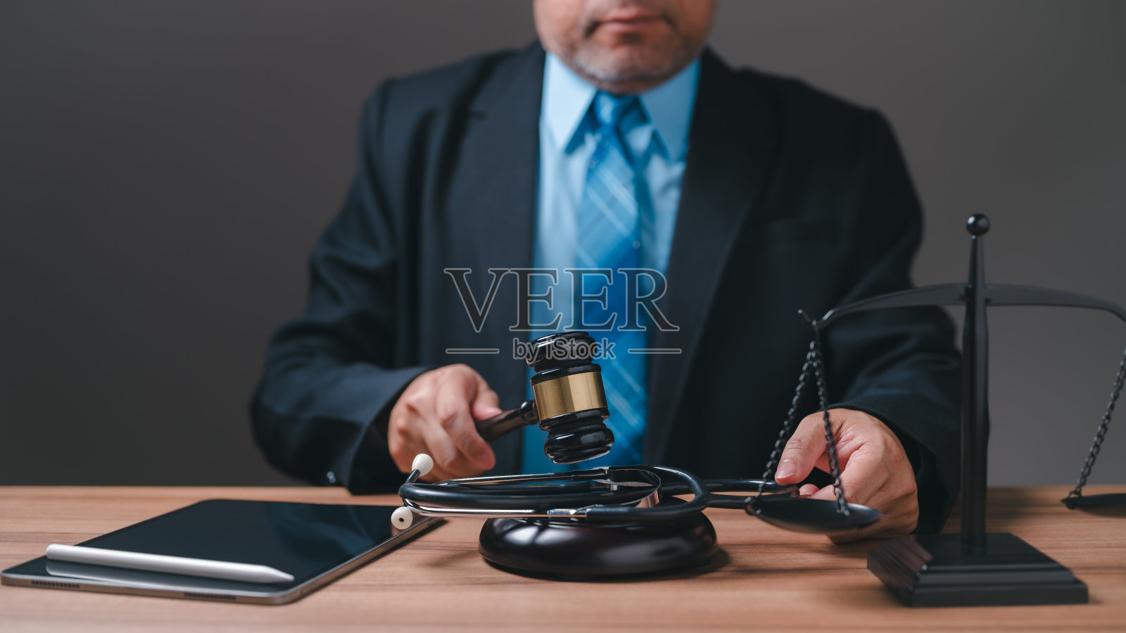 西装男人拿着法槌站在天平前，象征权威与专业，可能是法官或律师照片摄影图片