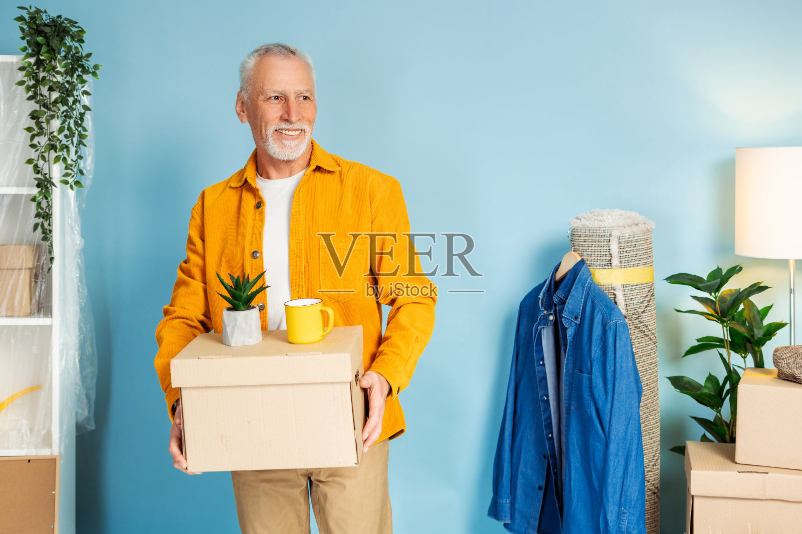 积极成熟的男人在家里拿着橱柜里的东西照片摄影图片