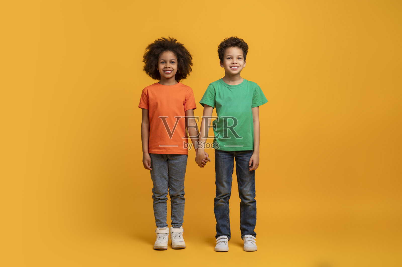 两个非裔美国孩子站在一起，手牵着手照片摄影图片