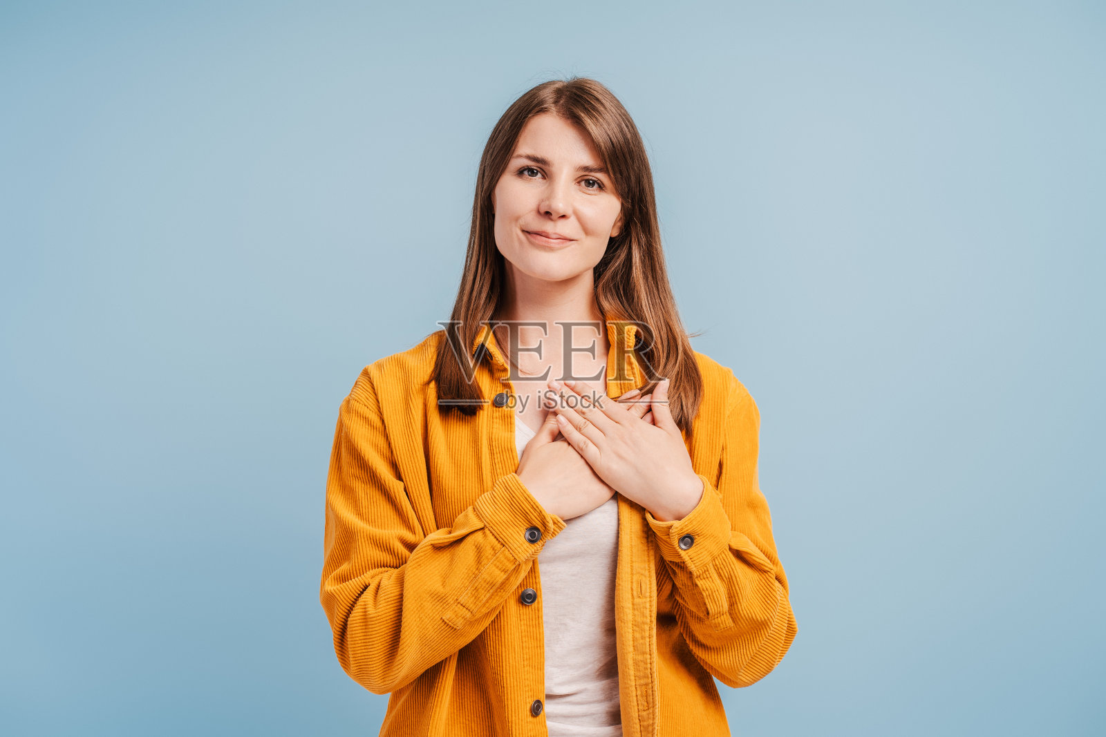 一幅悲伤的年轻女子的肖像，双手捂着心口，做着手势，索要着什么照片摄影图片