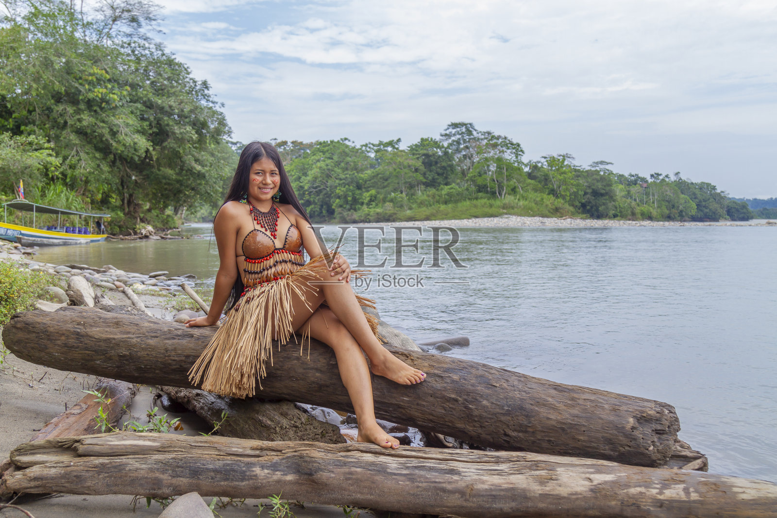 一位年轻美丽的土著女性肖像，穿着部落的传统服装，在村庄里拍摄，背景是亚马逊河。基奇瓦部落。照片摄影图片