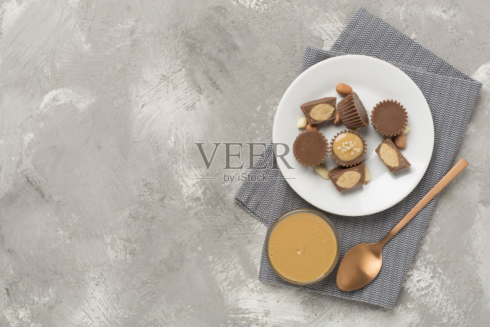 美味的花生酱杯和坚果在混凝土背景，俯视图照片摄影图片