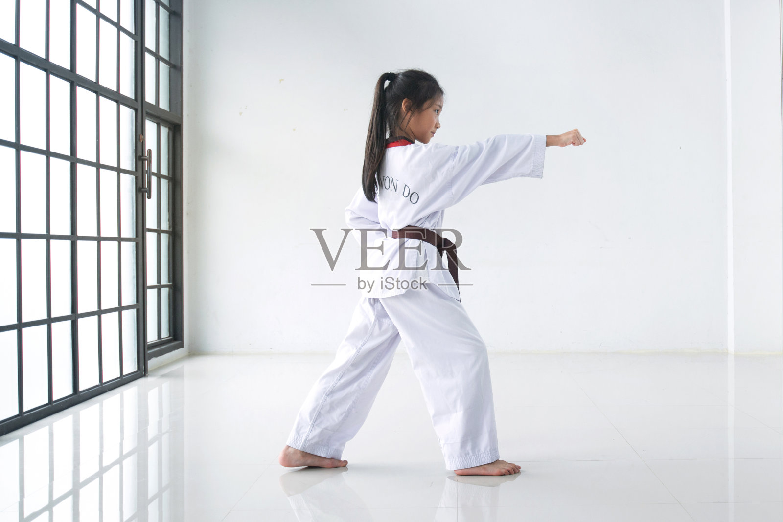 小女孩在训练室练习跆拳道动作，武术训练照片摄影图片
