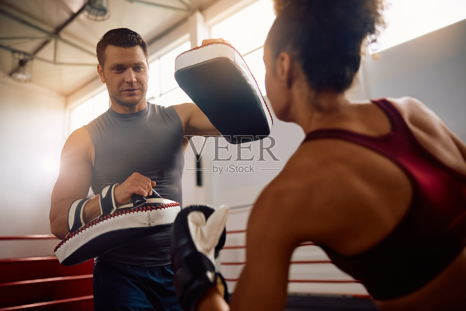 拳击教练和女运动员在健身俱乐部锻炼。照片摄影图片