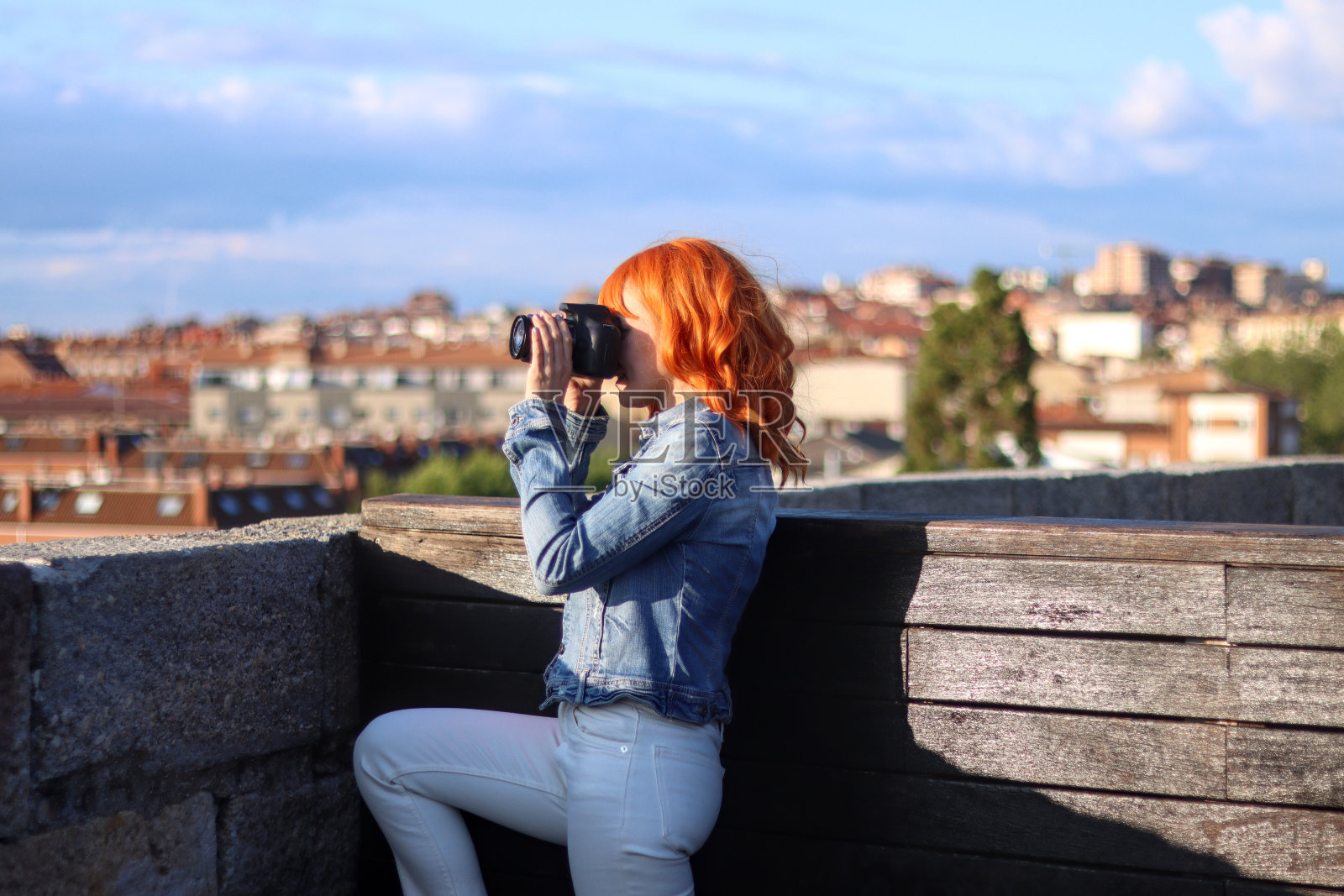 年轻的红发女子在一个视点使用相机照片摄影图片