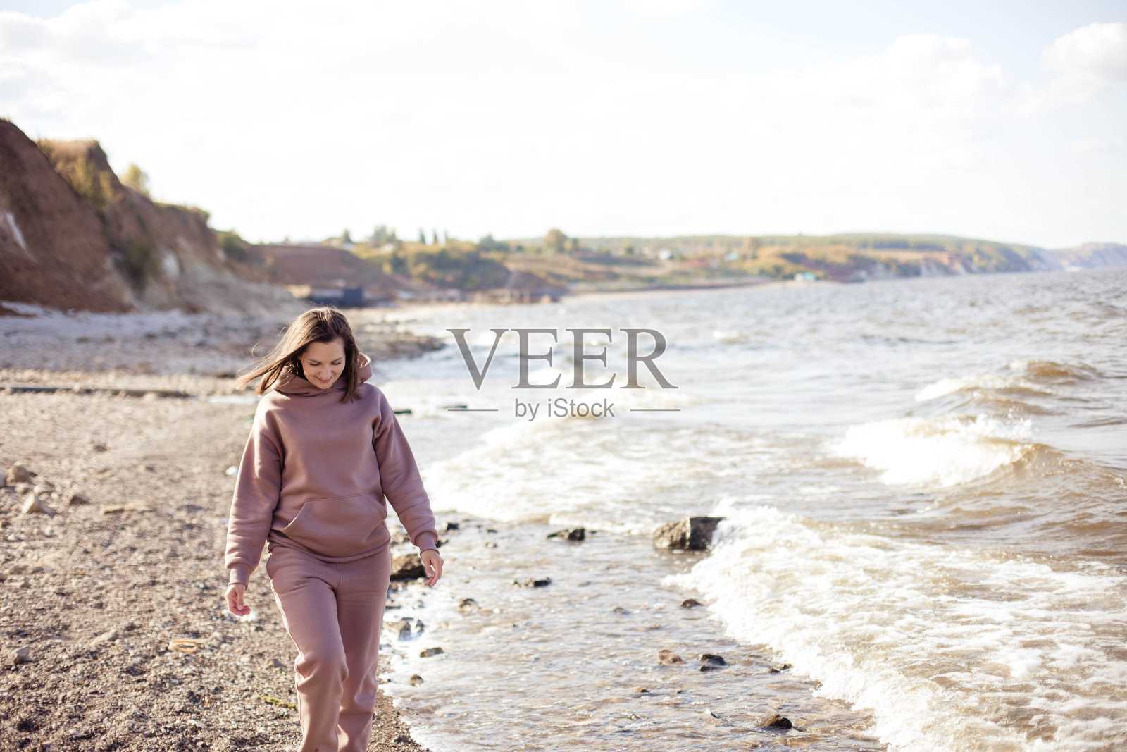 在海边散步的年轻女子照片摄影图片