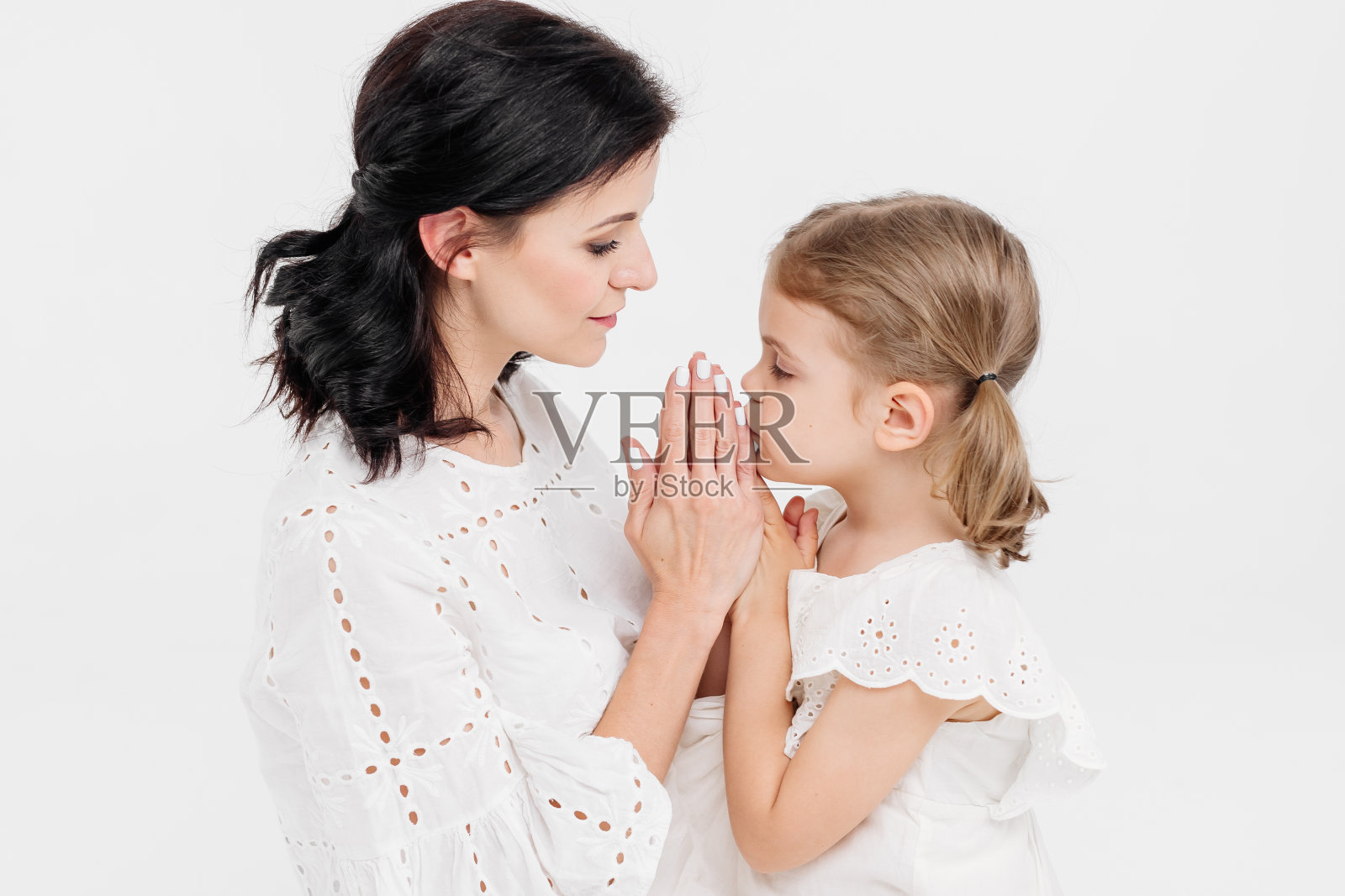 在浅色背景下，一对感人而温柔的母女的特写。妈妈温柔的抚摸。家庭的概念。照片摄影图片