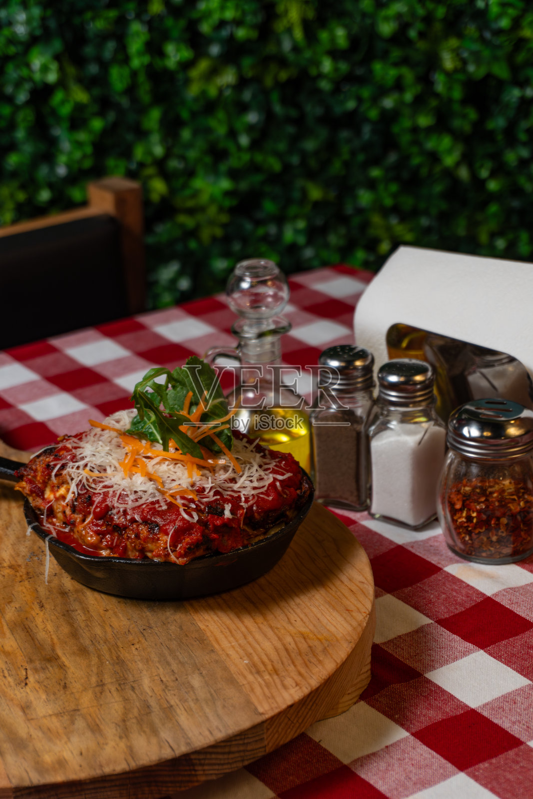 红色方格桌布上的美食煎锅千层面照片摄影图片