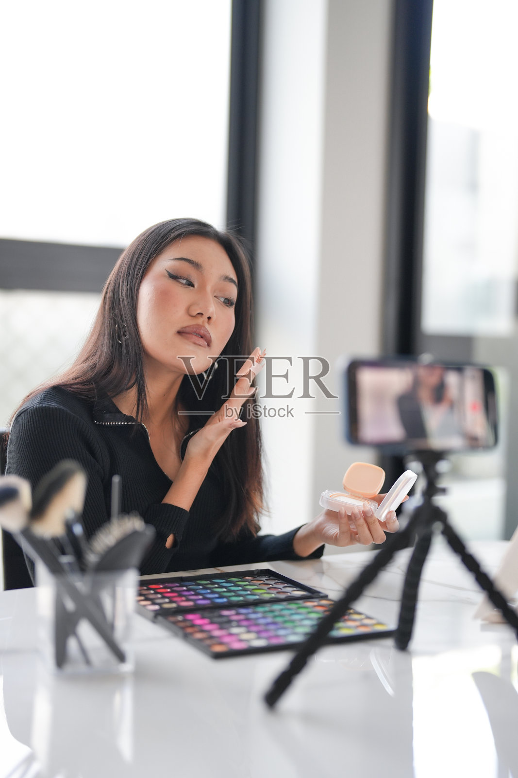 美妆网红亚洲女孩使用社交媒体在智能手机上进行直播，在线观众喜欢并订阅她的频道。比如，关注者，评论照片摄影图片