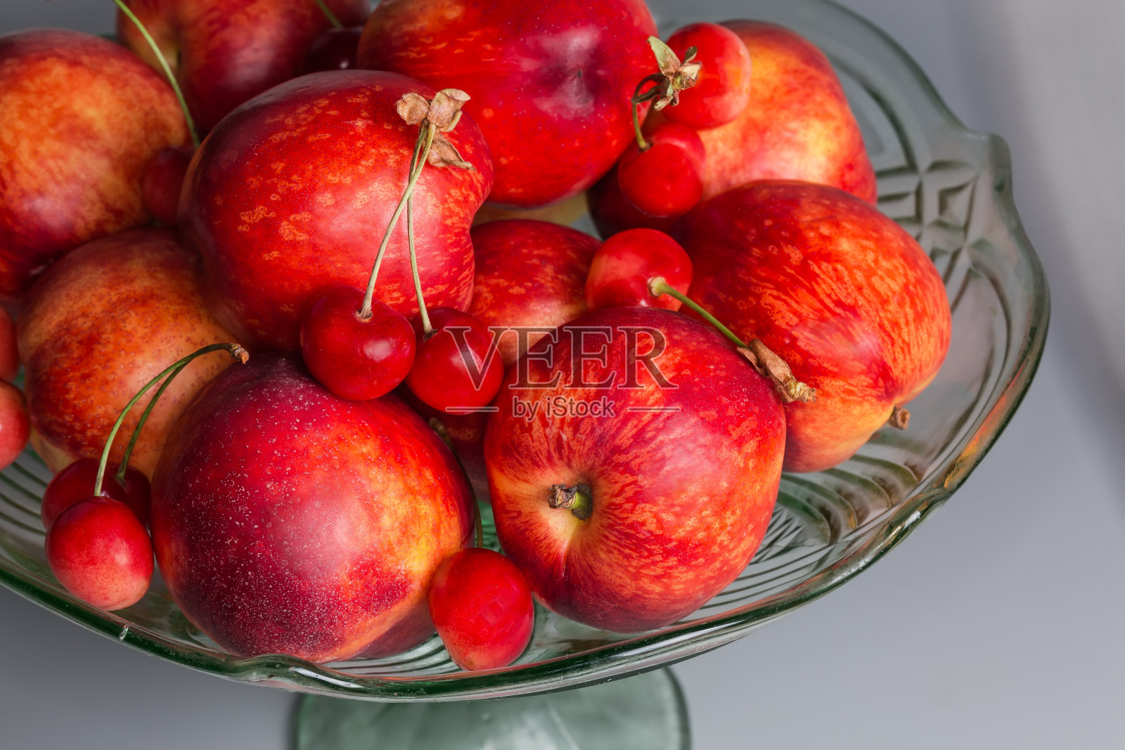 油桃和甜樱桃在复古的绿色玻璃果盘照片摄影图片