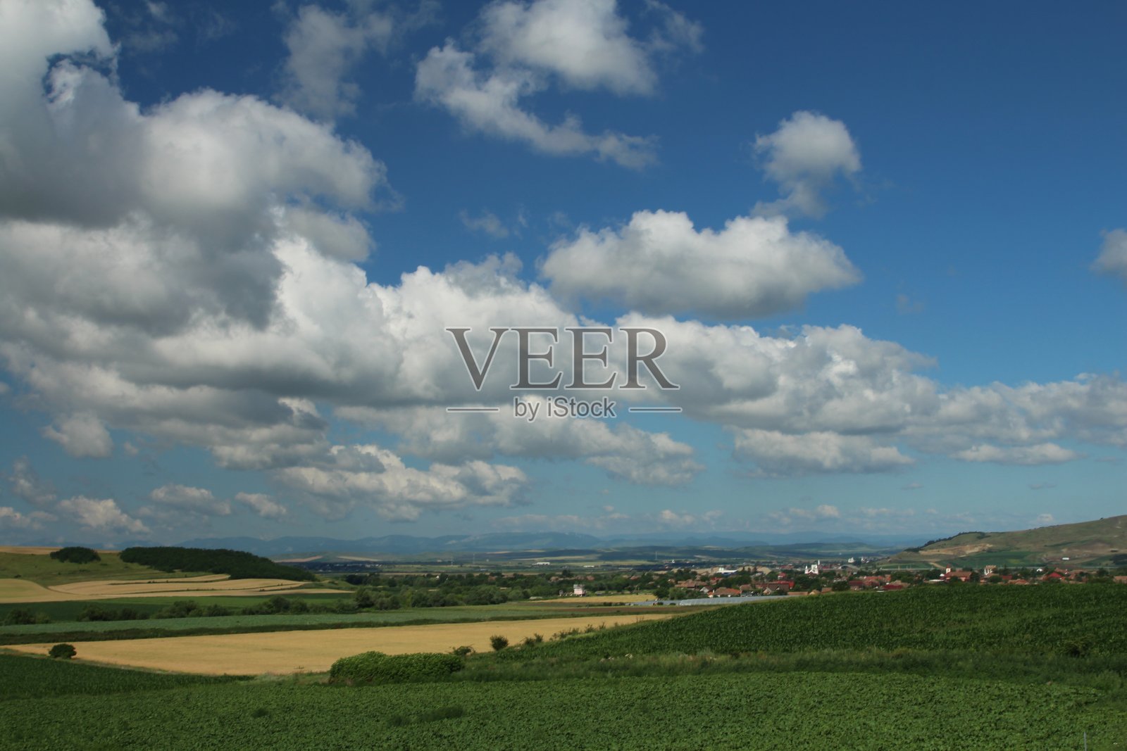 一片草地，远处是一个小镇照片摄影图片