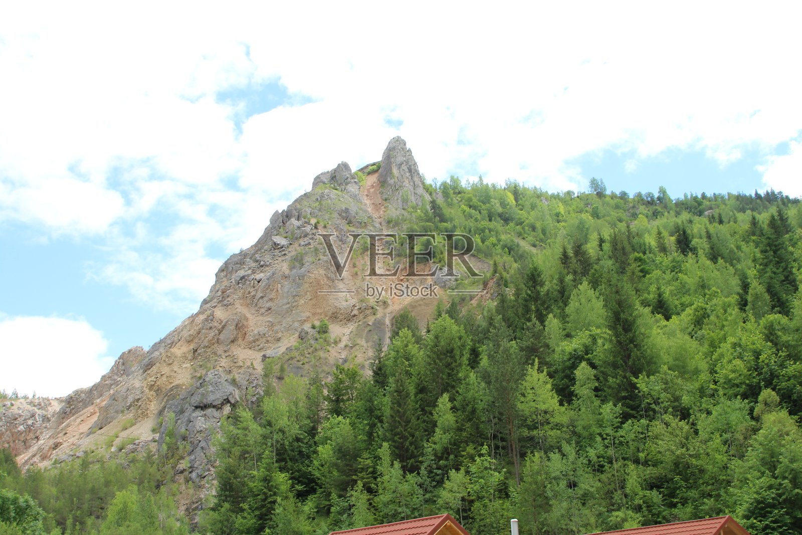 一座山，前面有树和一座建筑照片摄影图片