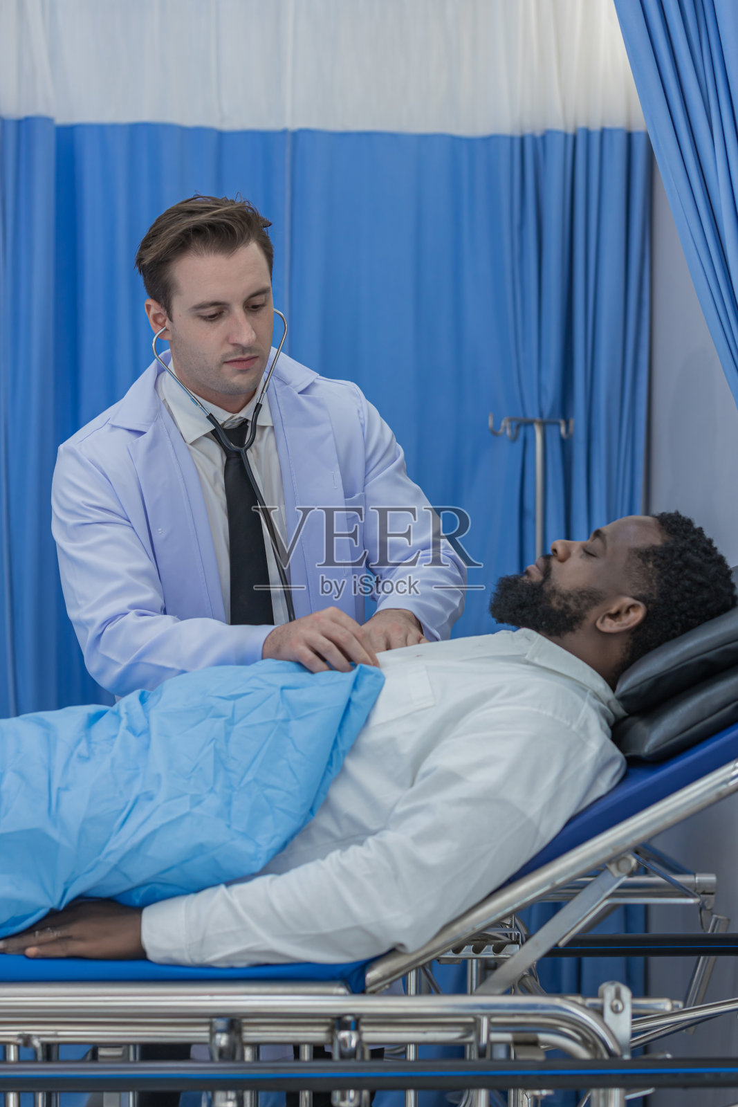 医生拜访病房里的病人。住院的男子躺在床上，医生正在检查他的。医生在病房里检查病人。医院病房照片摄影图片