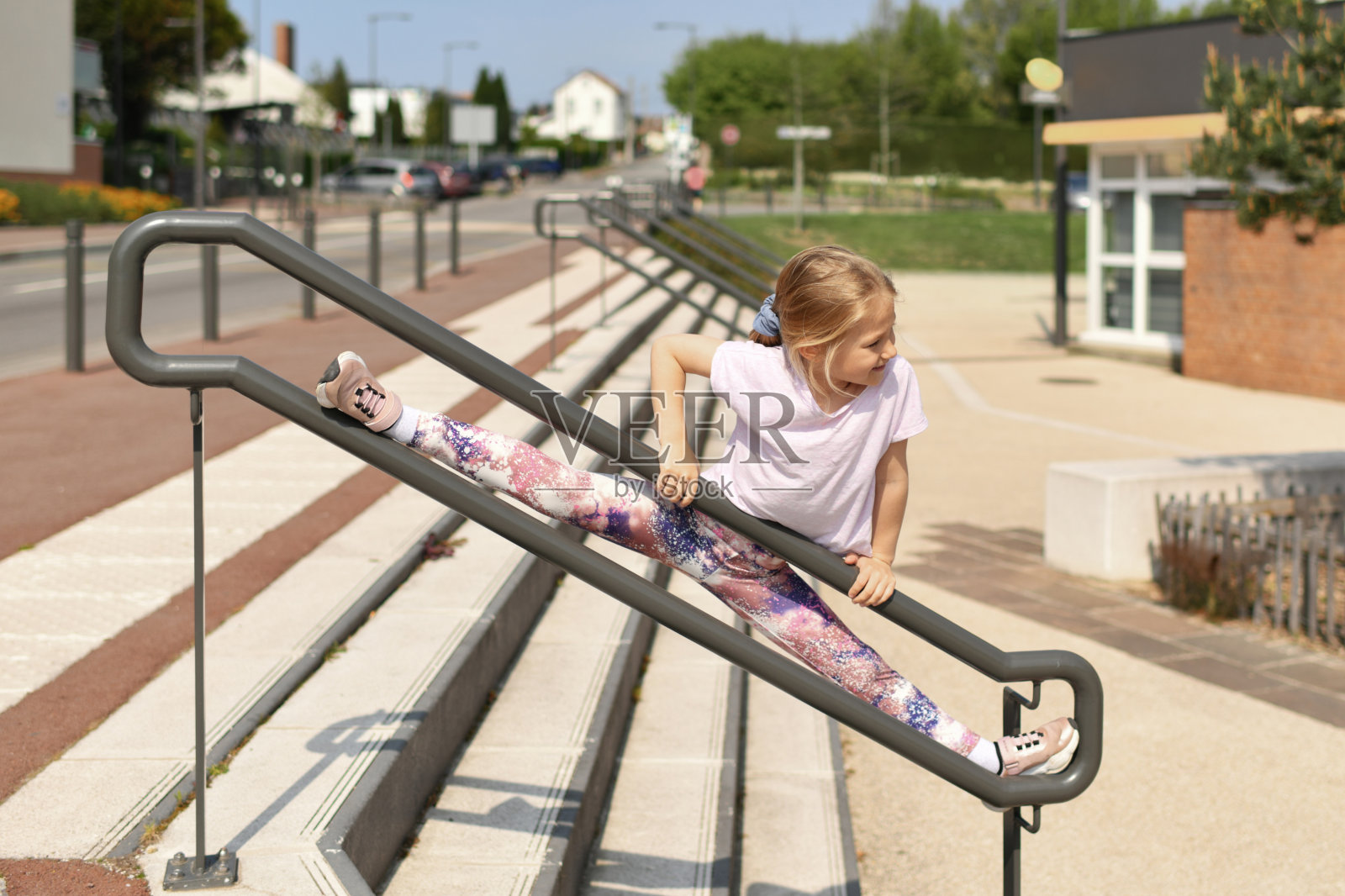 在城里做体操和劈叉的女孩照片摄影图片
