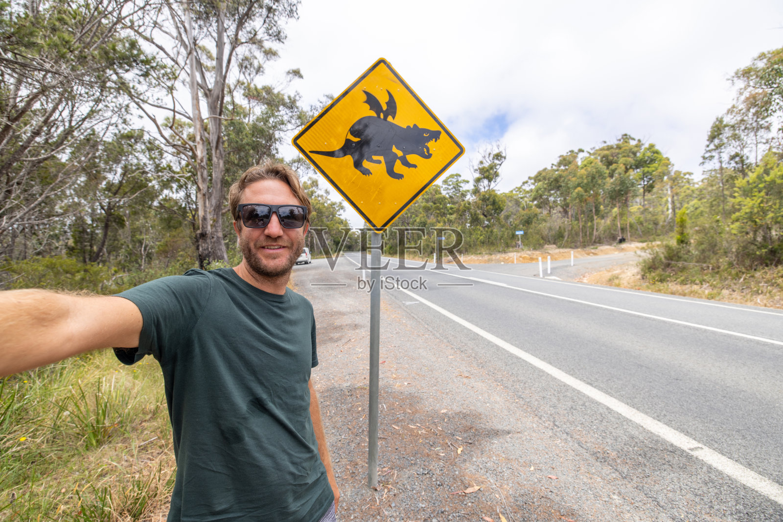 一名男子与幽默的塔斯马尼亚魔鬼十字路口标志自拍照片摄影图片