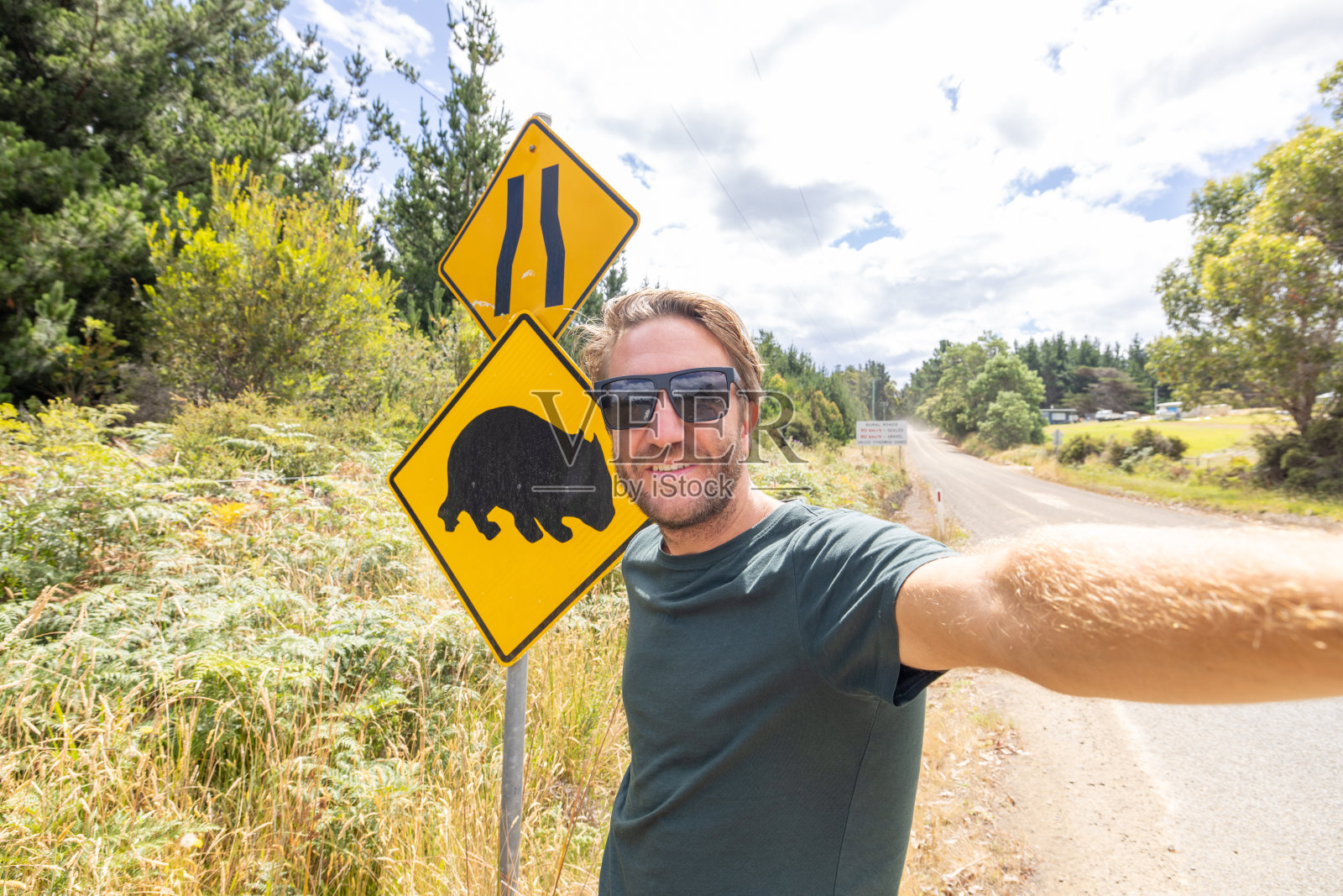 自驾游的男游客与袋熊十字路口的标志自拍照片摄影图片