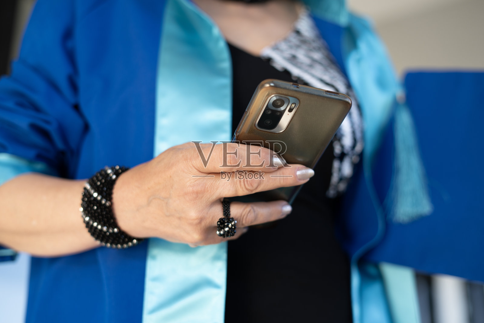 特写:刚毕业的大四女生在用智能手机照片摄影图片