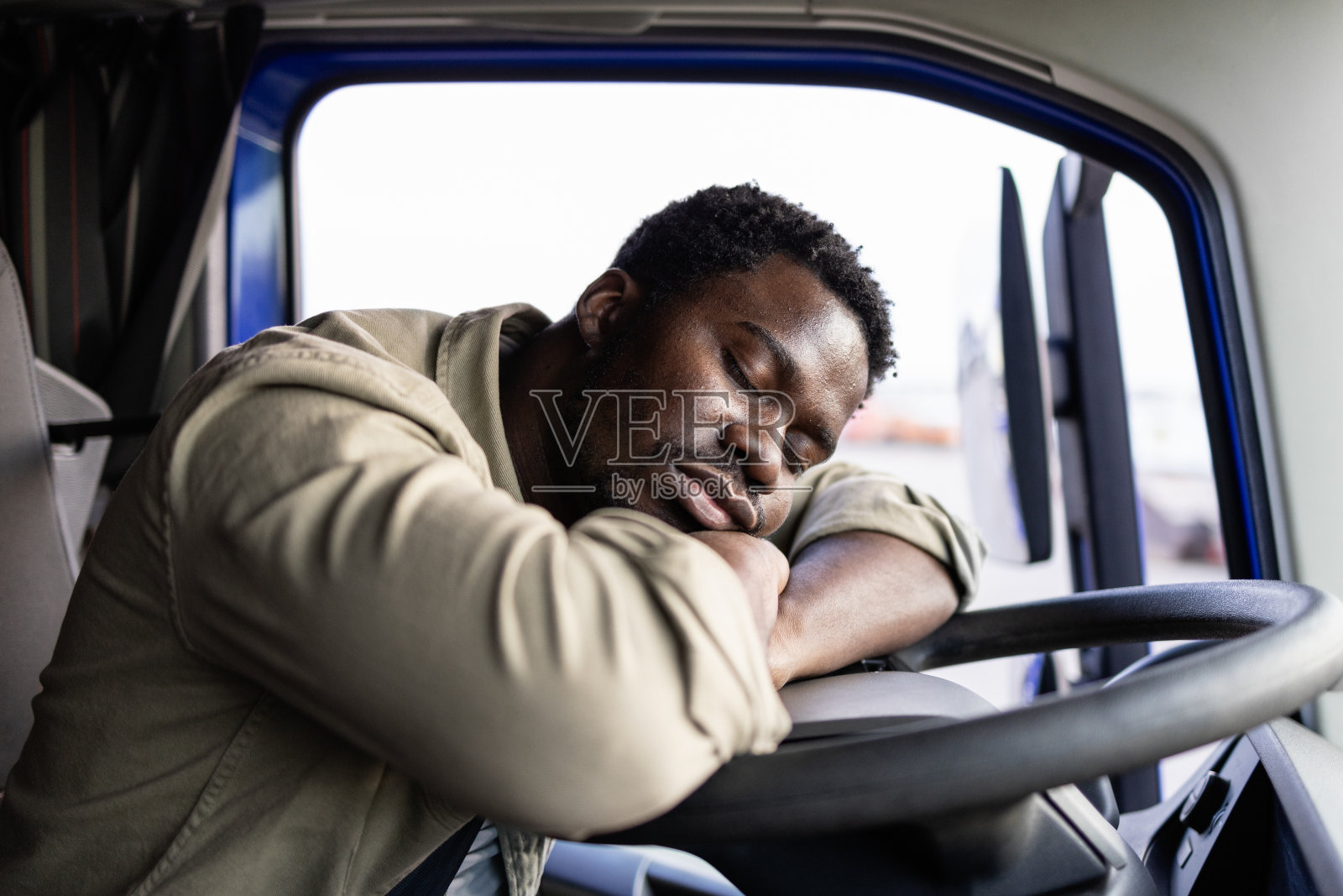 劳累过度的卡车司机。照片摄影图片