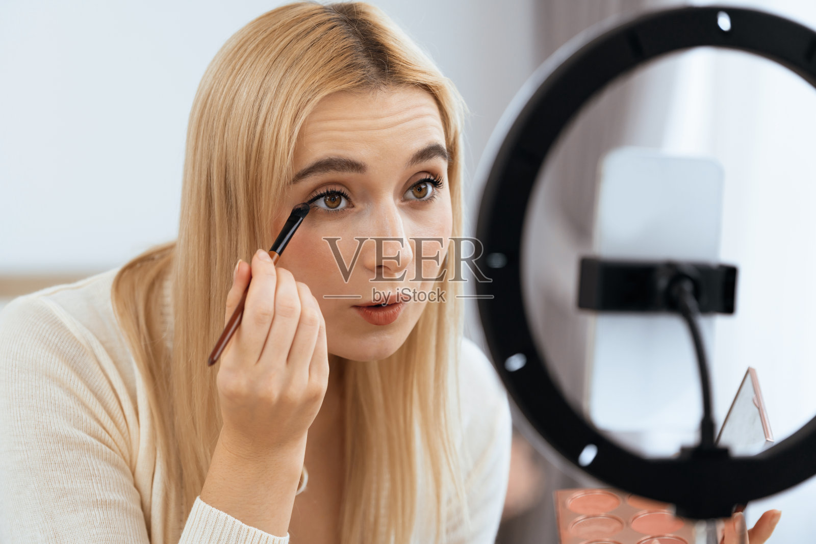 年轻女子制作美容美容教程视频内容。快乐无忧的照片摄影图片