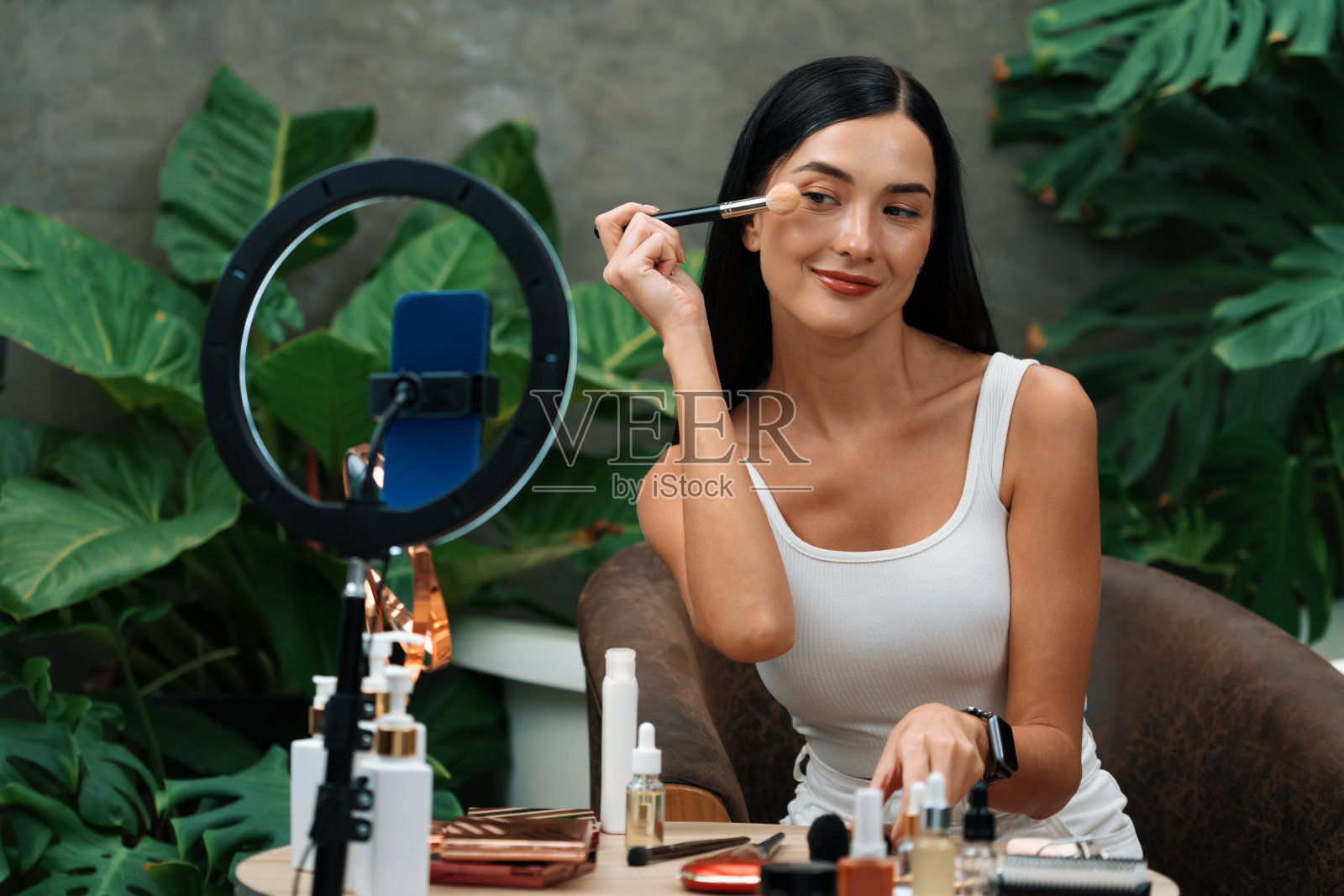 年轻女子制作美容美容教程视频内容。快乐无忧的照片摄影图片