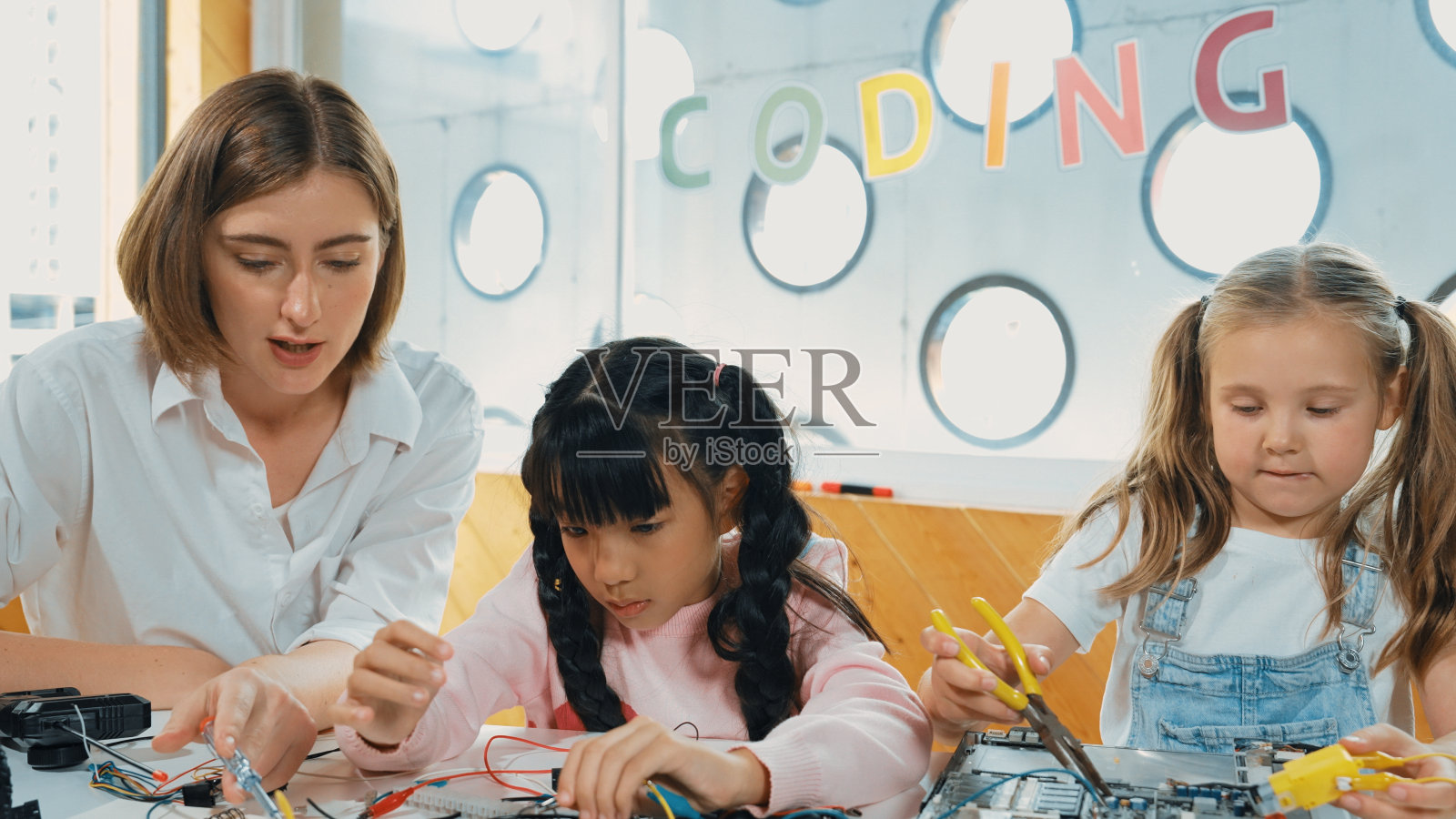 白人教师教学生数字电动工具。博学。照片摄影图片