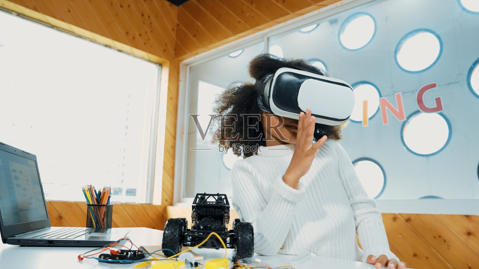 女孩戴着虚拟现实耳机在虚拟世界学习。未来的生活方式。博学。照片摄影图片